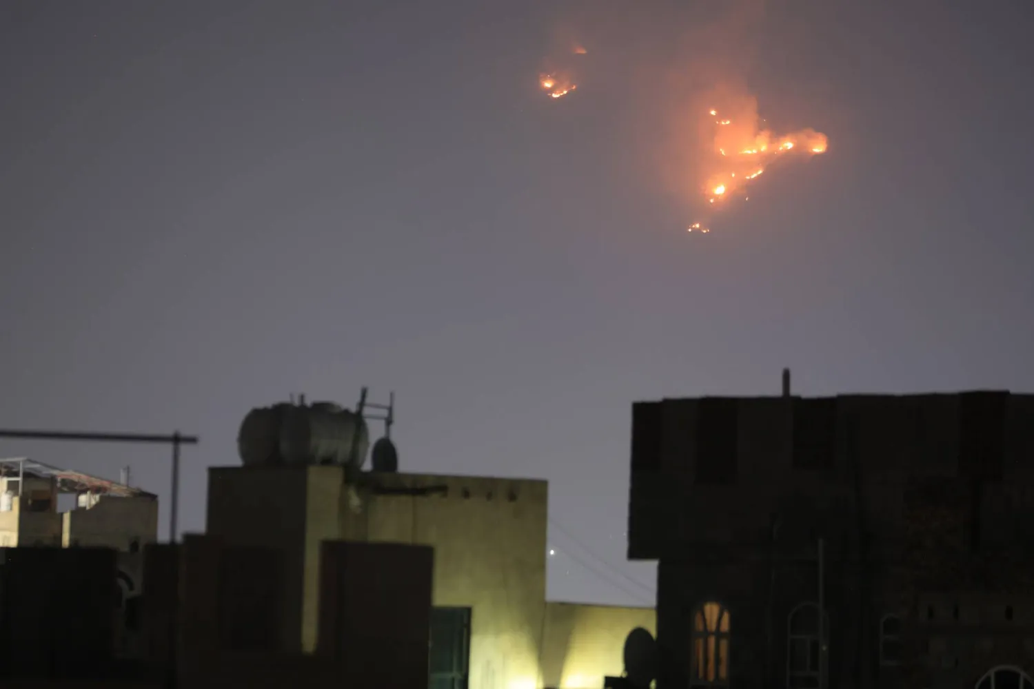 نيران تظهر في السماء بعد غارات جوية أميركية على اليمن (إ.ب.أ)