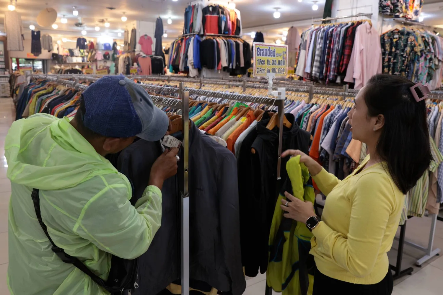 زبائن يتسوقون داخل متجر للملابس في إندونيسيا (إ.ب.أ)