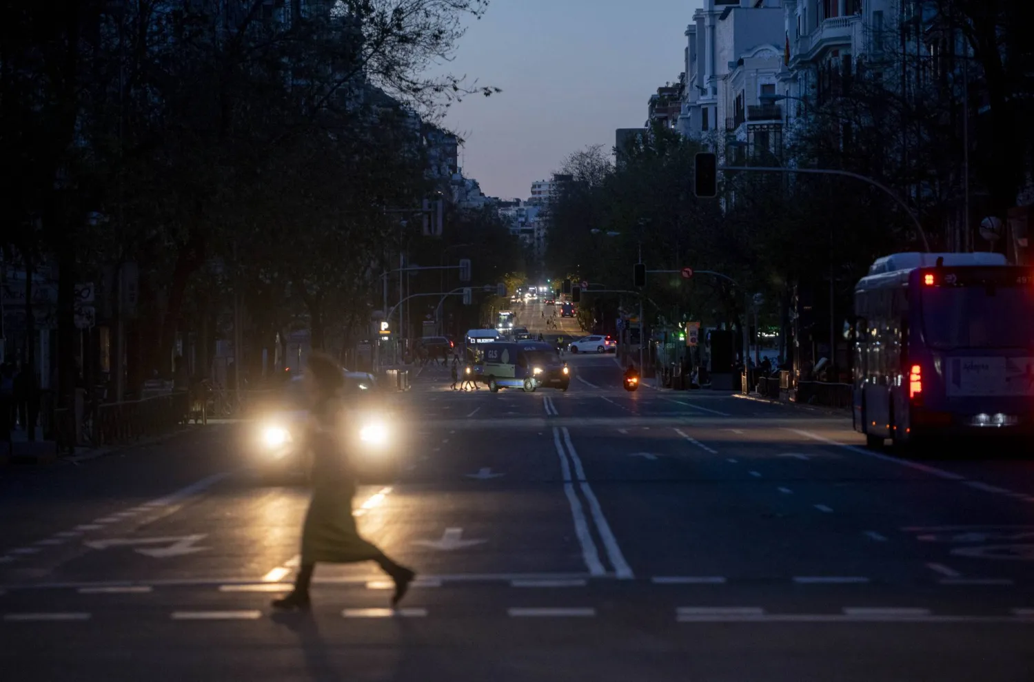 أشخاص يسيرون في شارع مظلم بمدريد (د.ب.أ)