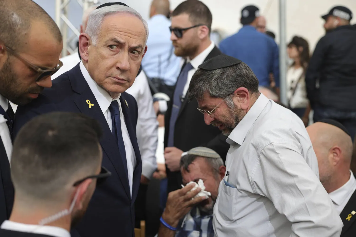 رئيس الوزراء الإسرائيلي بنيامين نتنياهو (يسار) مع والد أحد الجنود الإسرائيليين القتلى (أ.ب)