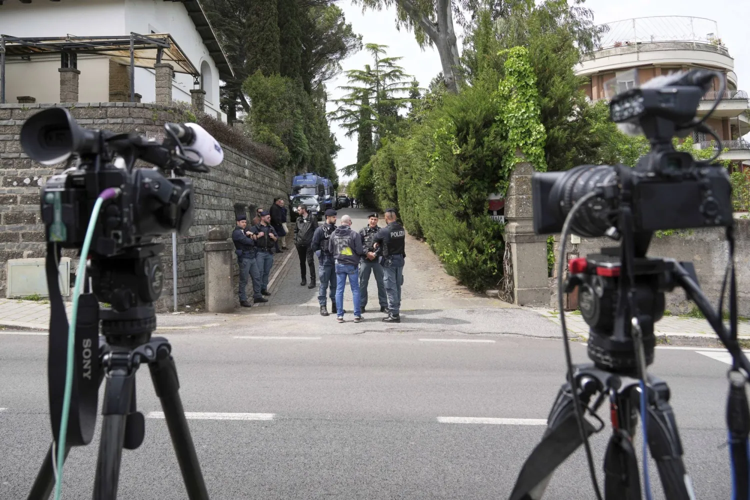 عناصر شرطة وصحافيون أمام مدخل سفارة سلطنة عمان في روما حيث جرت جولة التفاوض الثانية بين الولايات المتحدة وإيران (أ.ب)