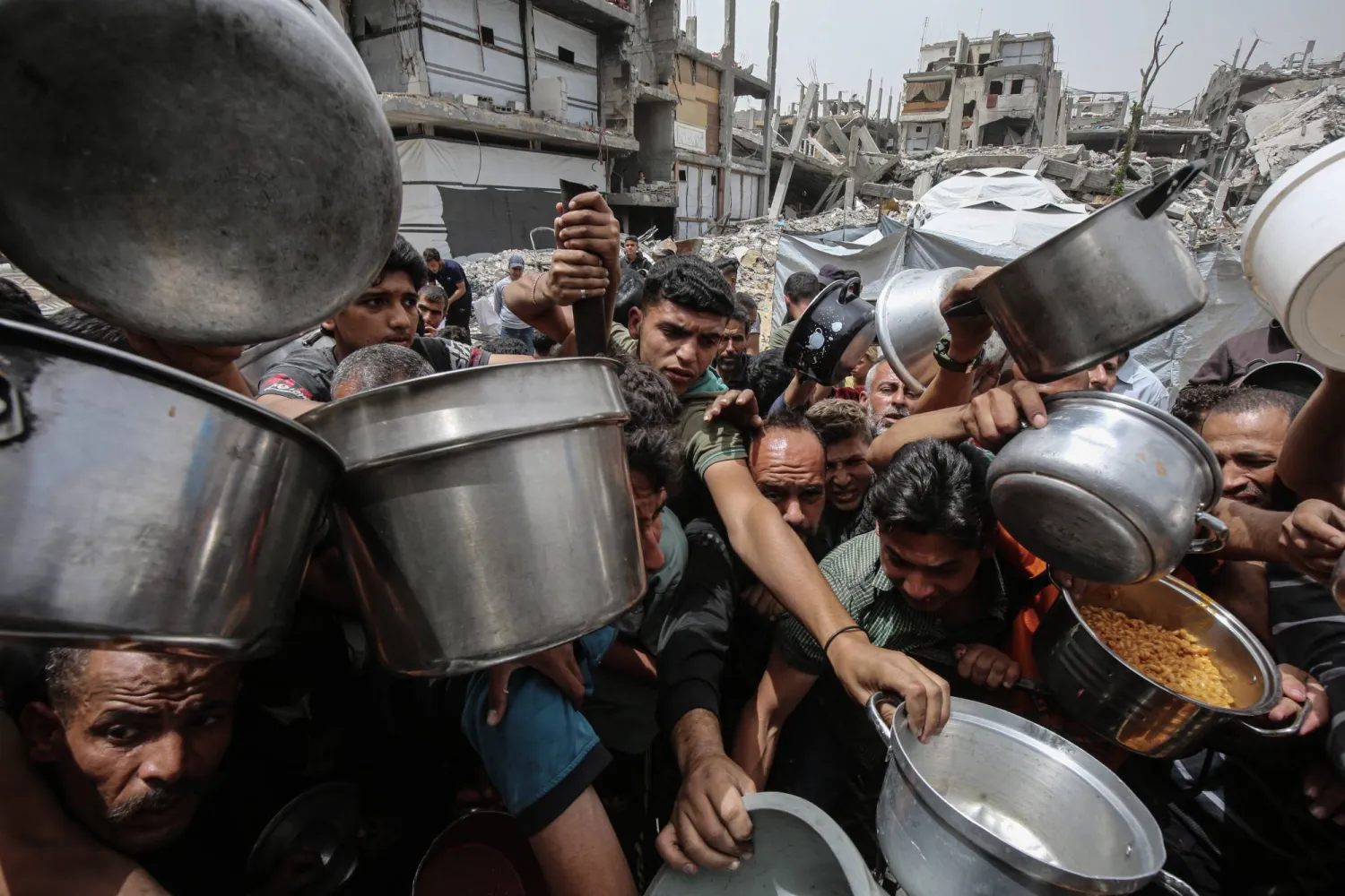 تدافُع للحصول على وجبات ساخنة من منظمات خيرية في جباليا شمال قطاع غزة يوم الأربعاء (د.ب.أ)