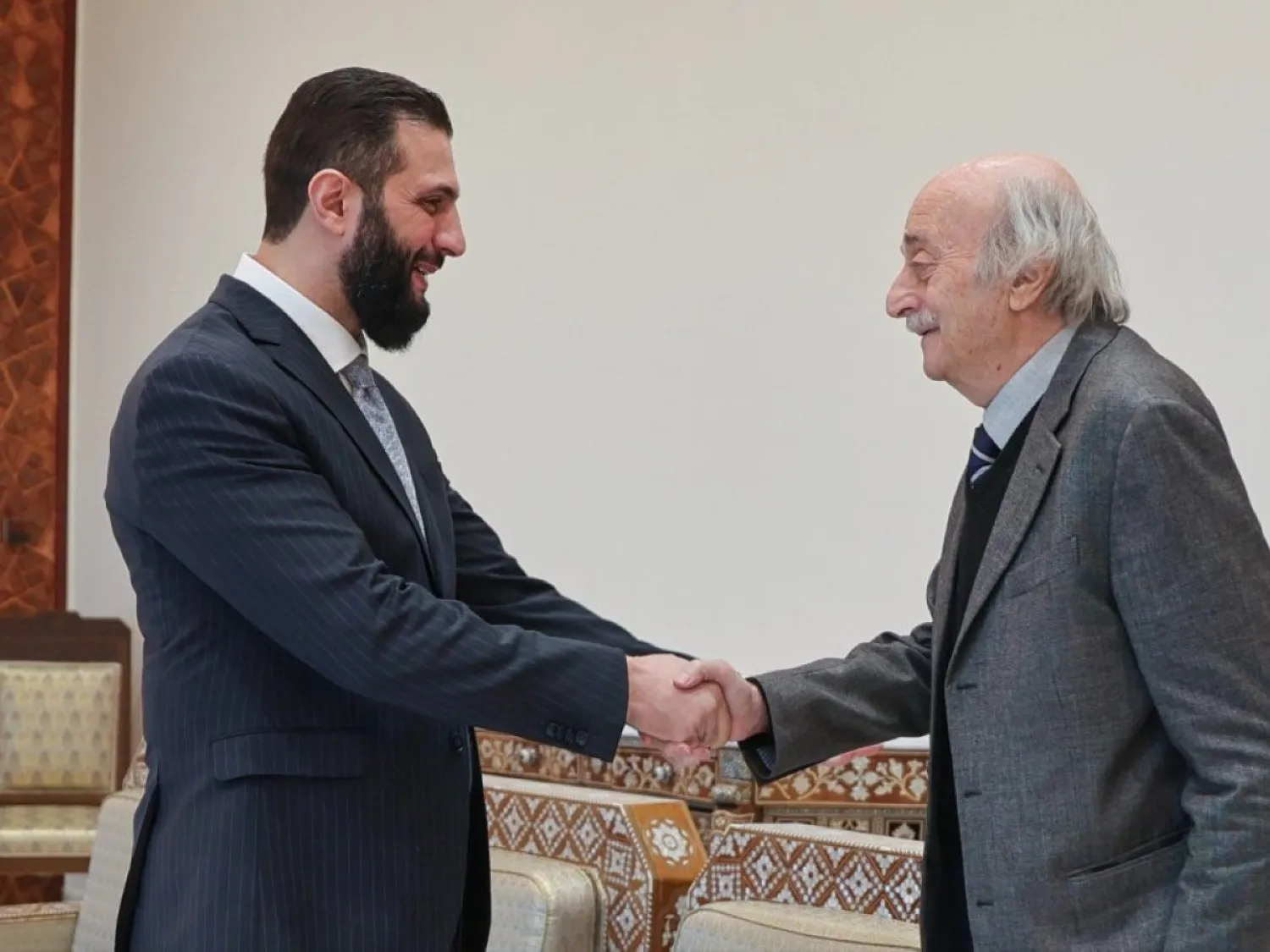 الرئيس السوري أحمد الشرع يصافح الزعيم الدرزي وليد جنبلاط في قصر الشعب بدمشق (الرئاسة السورية)