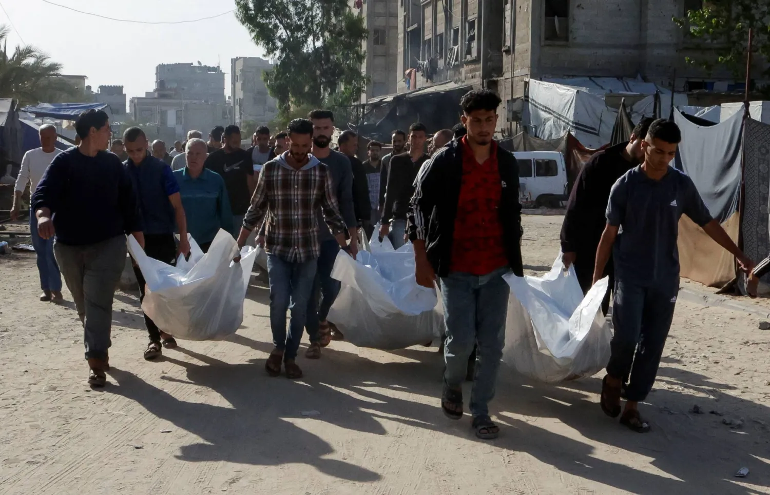 فلسطينيون يحملون جثامين ضحايا الضربات الإسرائيلية خلال جنازتهم في خان يونس اليوم (رويترز)