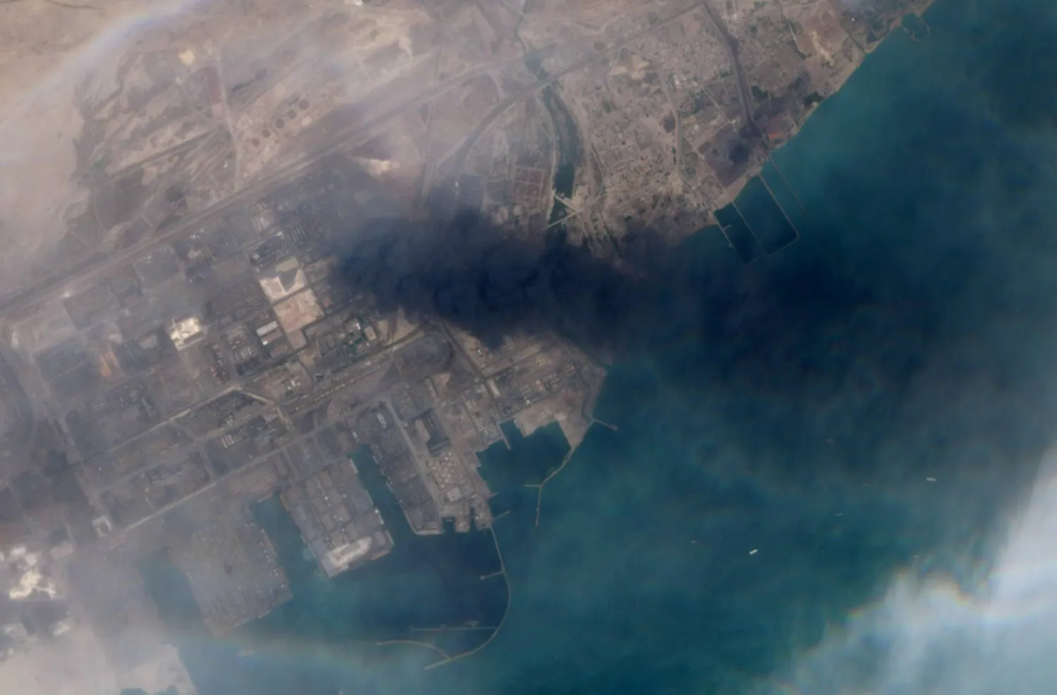 صورة فضائية من قمر «ماكسار» تُظهر تصاعد الدخان من الانفجار في رصيف «رجائي» بميناء «بندر عباس» جنوب إيران (رويترز)
