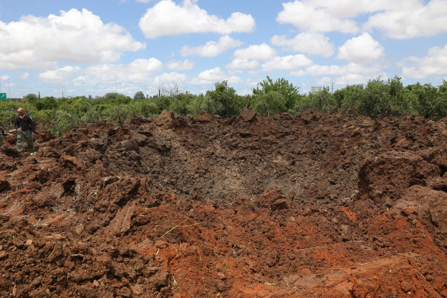 جانب من الأضرار جراء سقوط صاروخ أطلقه الحوثيون قرب مطار بن غوريون في تل أبيب (إ.ب.أ)