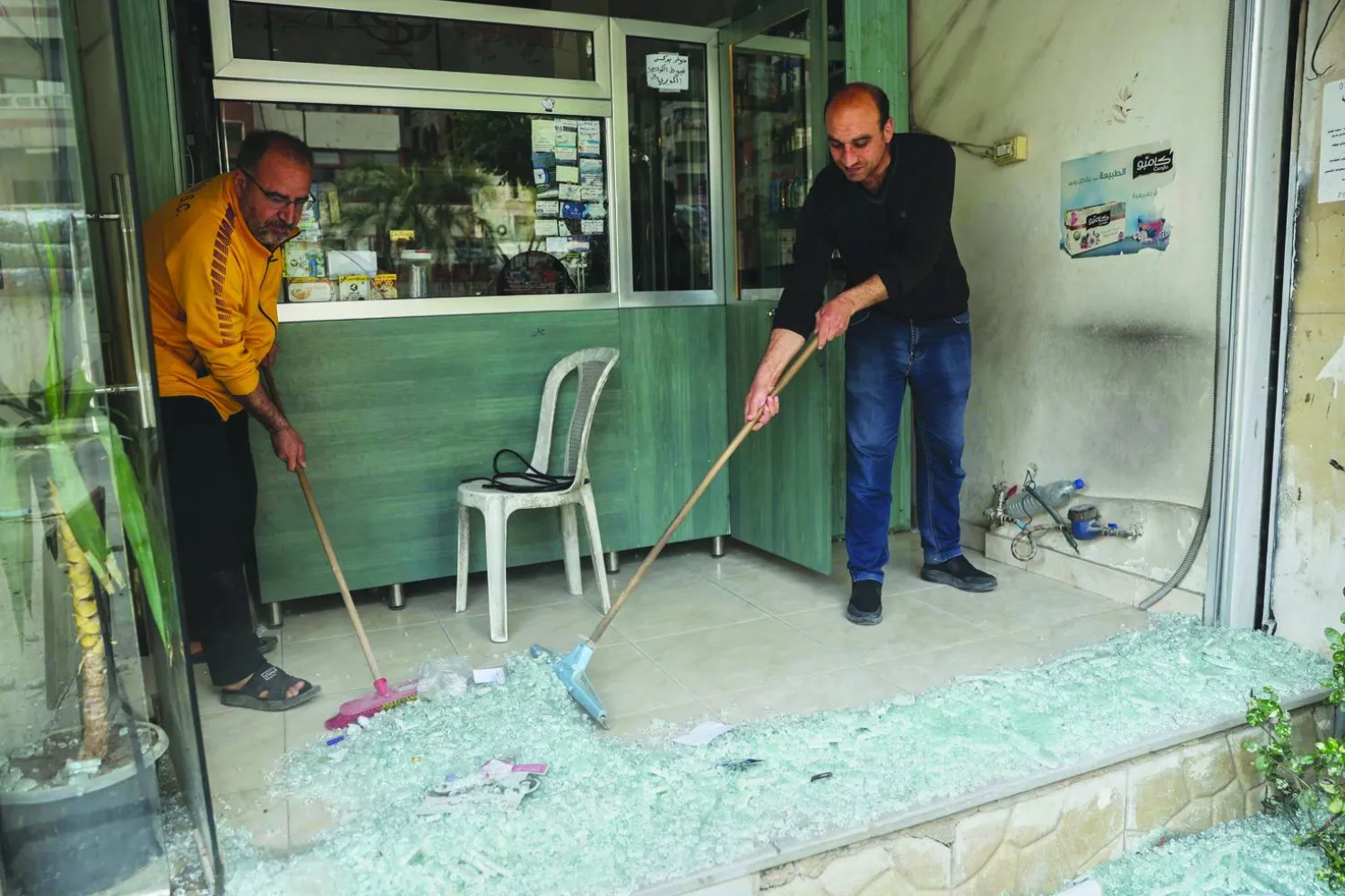 
صاحب محل ينظف الزجاج بعد أحداث صحنايا قرب دمشق (أ.ب) وفي الإطار  المتحدث باسم حركة «رجال الكرامة» باسم أبو فخر (فيسبوك)