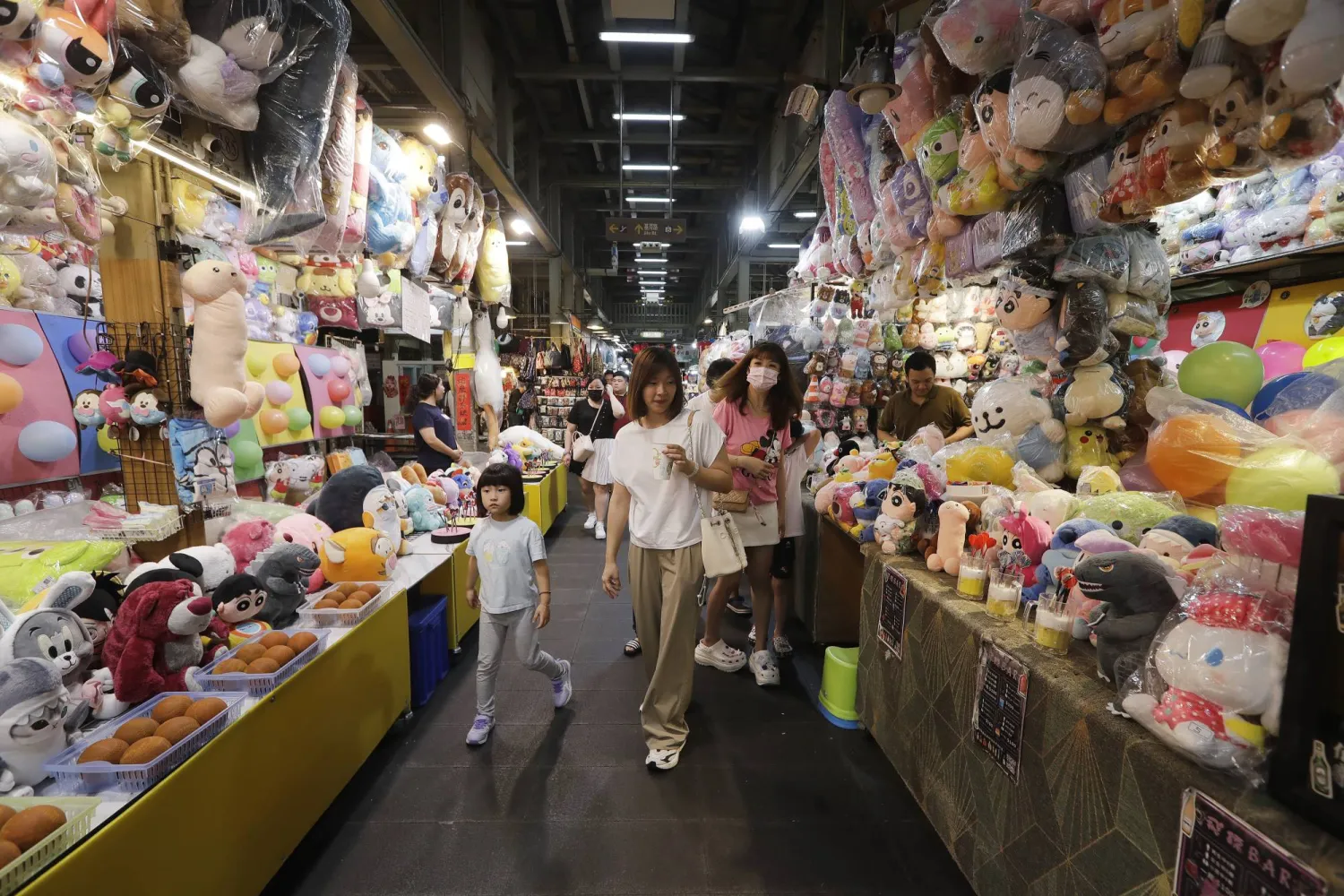 زوار لسوق شعبية في العاصمة التايوانية تايبيه (أ.ب)