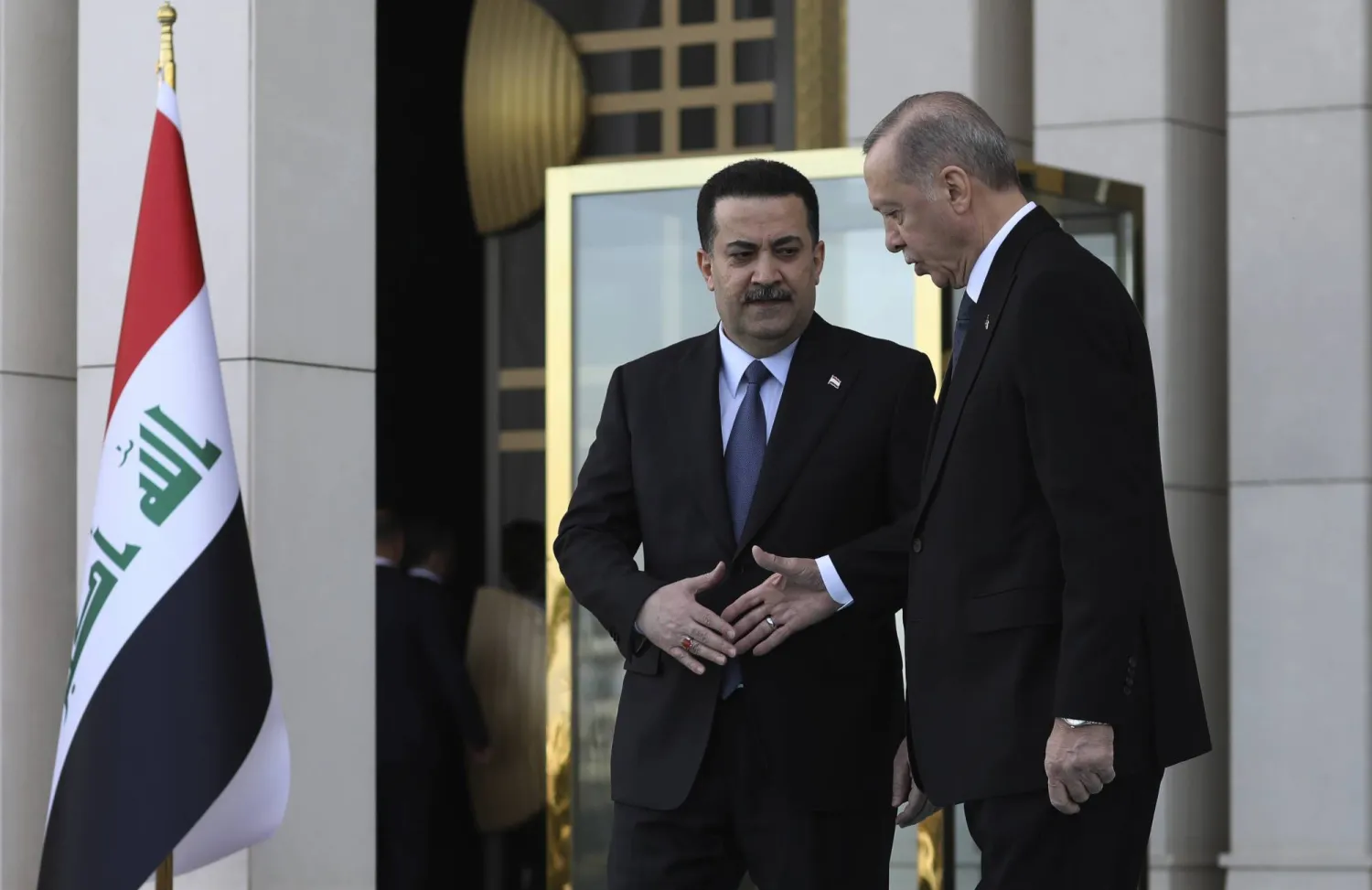 الرئيس التركي رجب طيب إردوغان ورئيس الوزراء العراقي محمد شياع السوداني يتصافحان خلال حفل ترحيب بأنقرة في مارس 2023 (أ.ب)