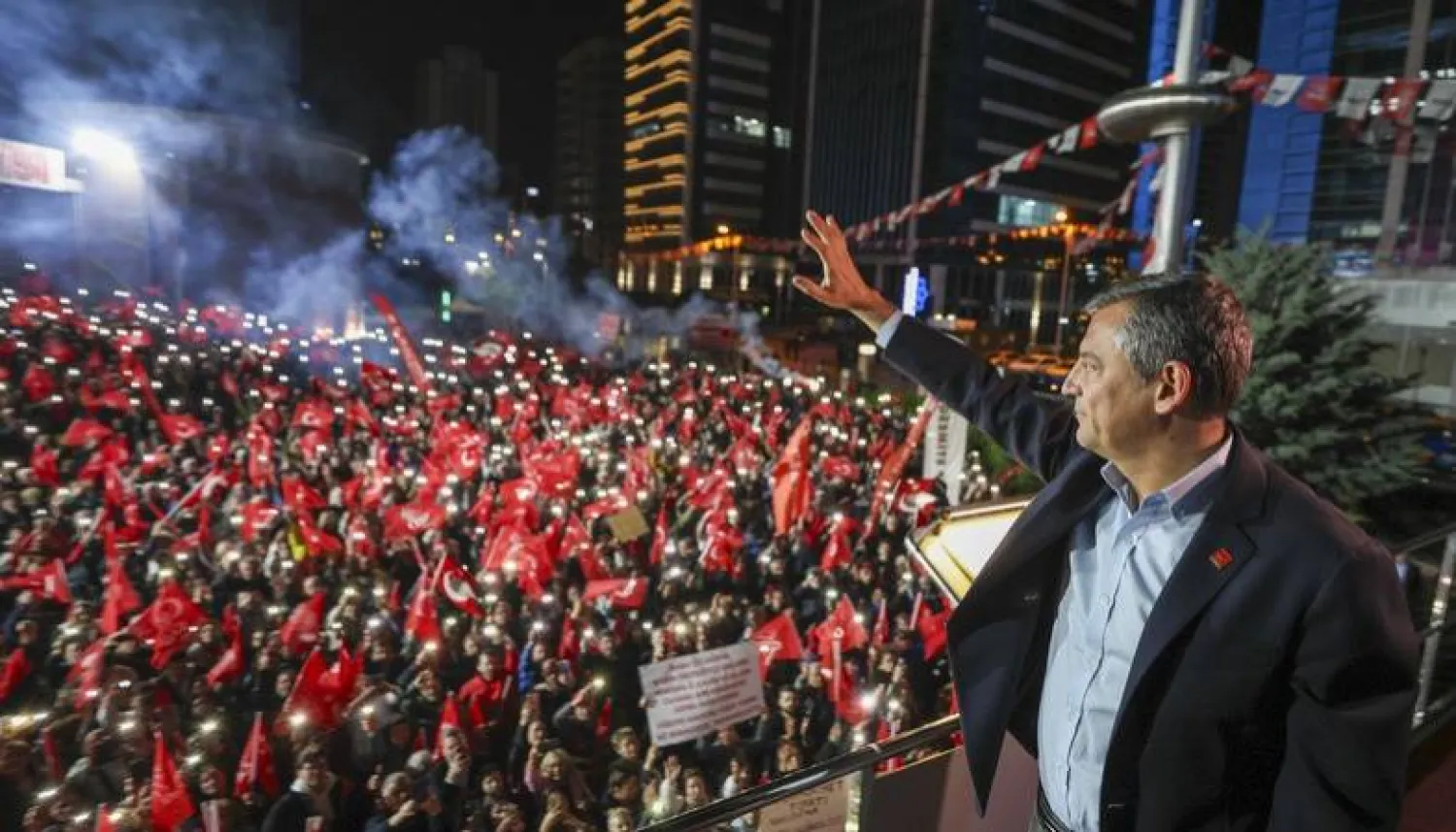 رئيس حزب الشعب الجمهوري أوزغور أوزيل يلوح لأنصار حزبه الذين تجمعوا ليل الأحد أمام مقره للترحيب به بعد تعرضه لاعتداء في إسطنبول (حزب الشعب الجمهوري - إكس)