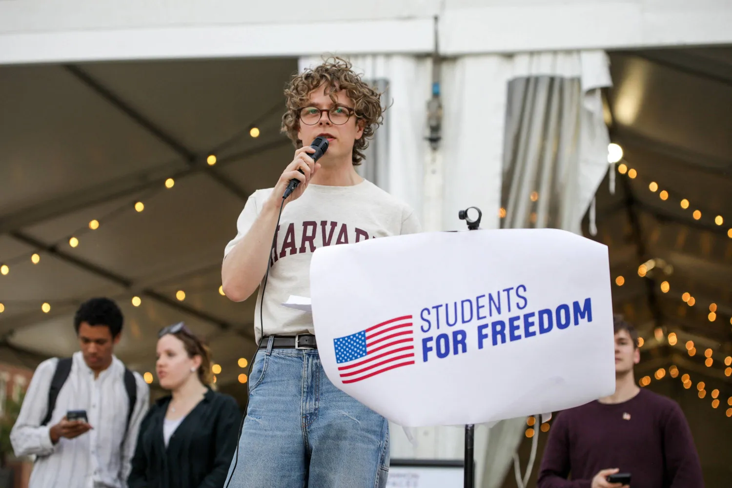 طالب يحتج داخل حرم جامعة هارفارد على إجراءات إدارة ترمب (رويترز)