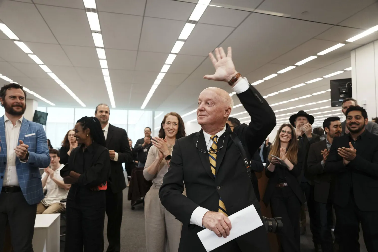 المصور الصحفي دوغ ميلز من صحيفة نيويورك تايمز يشيد بالتصفيق بعد فوزه بجائزة بوليتزر لتصويره محاولة اغتيال ترمب (أ.ب)