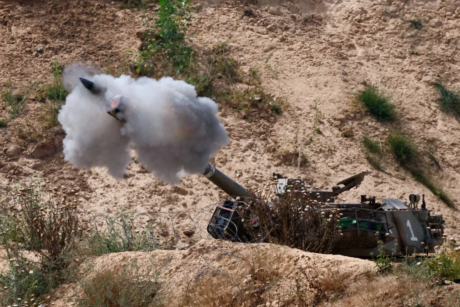 وحدة مدفعية إسرائيلية تطلق النار باتجاه غزة يوم الثلاثاء (رويترز)