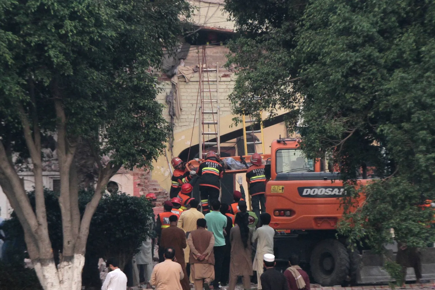 رجال الإنقاذ يسحبون جثة من مبنى تعرض لقصف هندي في موريدكي بالقرب من لاهور (رويترز)