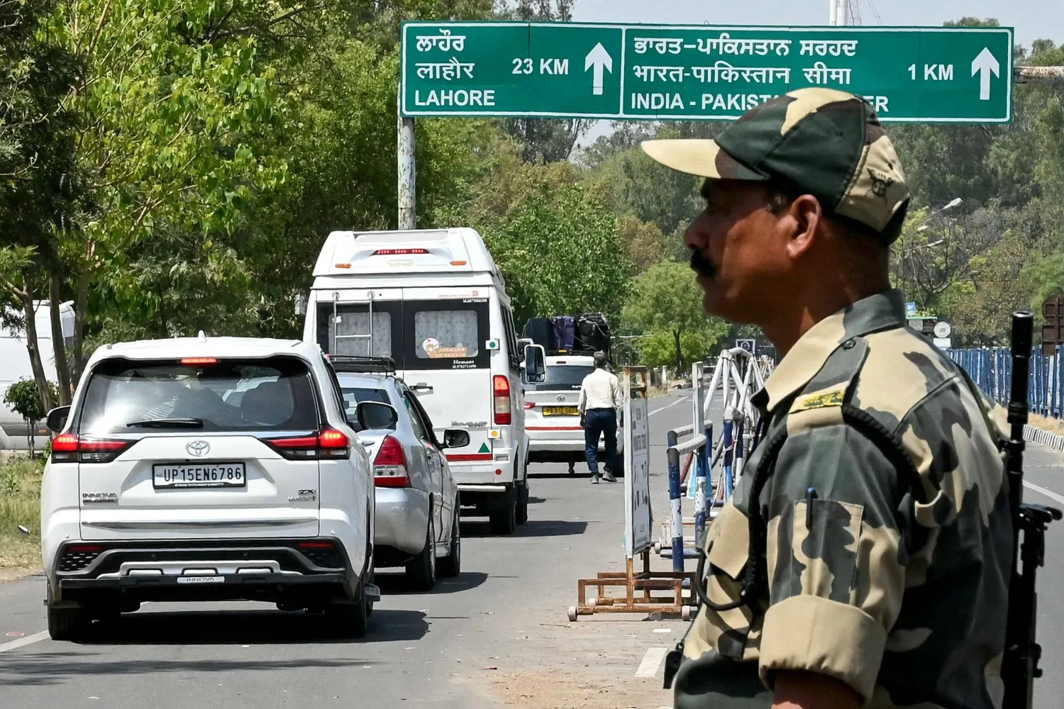 أحد أفراد قوة أمن الحدود الهندية يقف حارساً للمواطنين الباكستانيين العائدين إلى بلادهم عبر معبر «أتاري - واجا» الحدودي بين الهند وباكستان (أ.ف.ب)