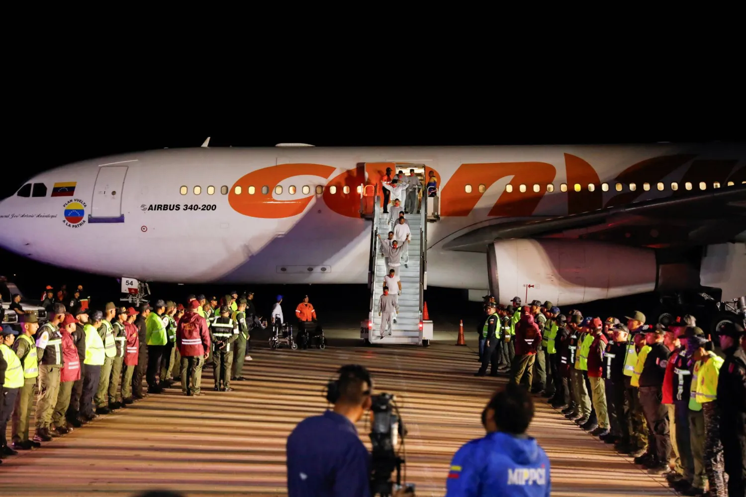 مهاجرون فنزويليون مرحّلون من قاعدة غوانتانامو البحرية الأميركية يصلون إلى مطار سيمون بوليفار الدولي في مايكيتيا بفنزويلا (رويترز)