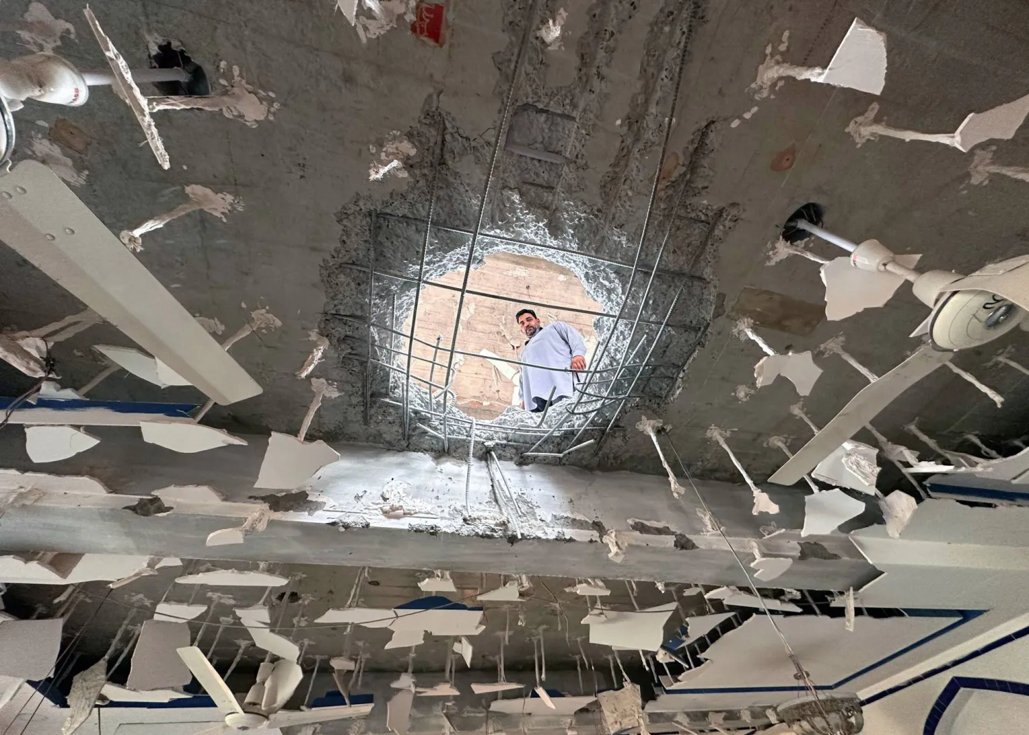 رجل يعاين الأضرار الناجمة عن هجمات صاروخية هندية طالت مبنى في مدينة كولتي بالشطر الباكستاني من كشمير أمس (إ.ب.أ)