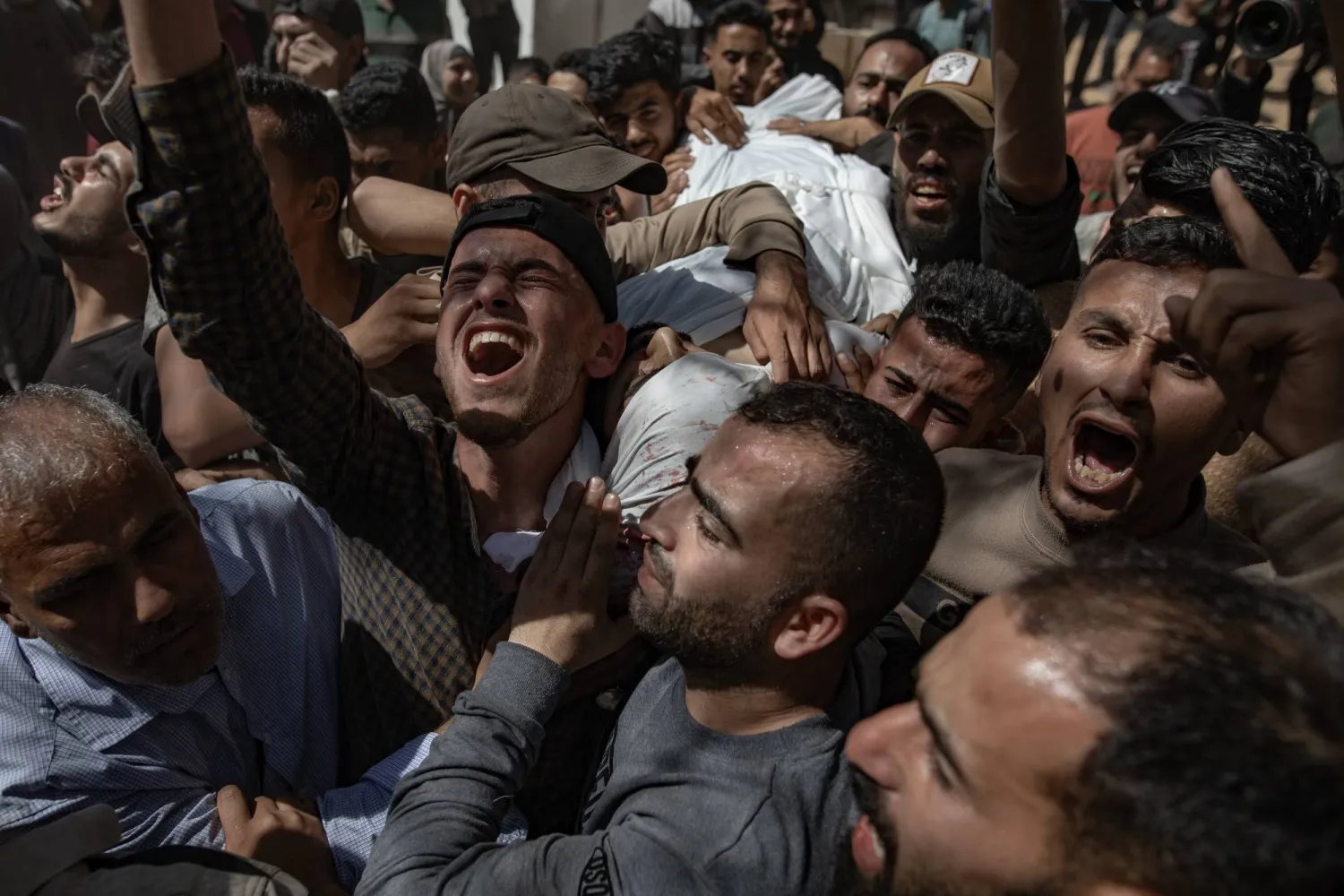 فلسطينيون ينعون أحد ضحايا غارة جوية إسرائيلية خلال جنازته في مدينة غزة (إ.ب.أ)