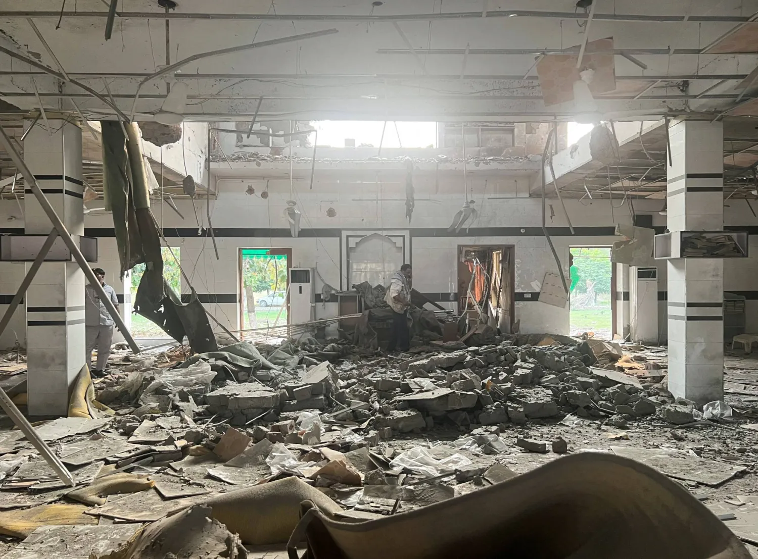 رجل يعاين الأضرار اللاحقة بمسجد لدى موريدكي قرب لاهور (رويترز)