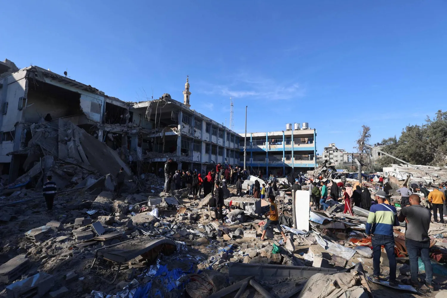 فلسطينيون يسيرون في مدرسة تؤوي نازحين بعد غارة إسرائيلية على مخيم البريج للاجئين في وسط قطاع غزة (أ.ف.ب)