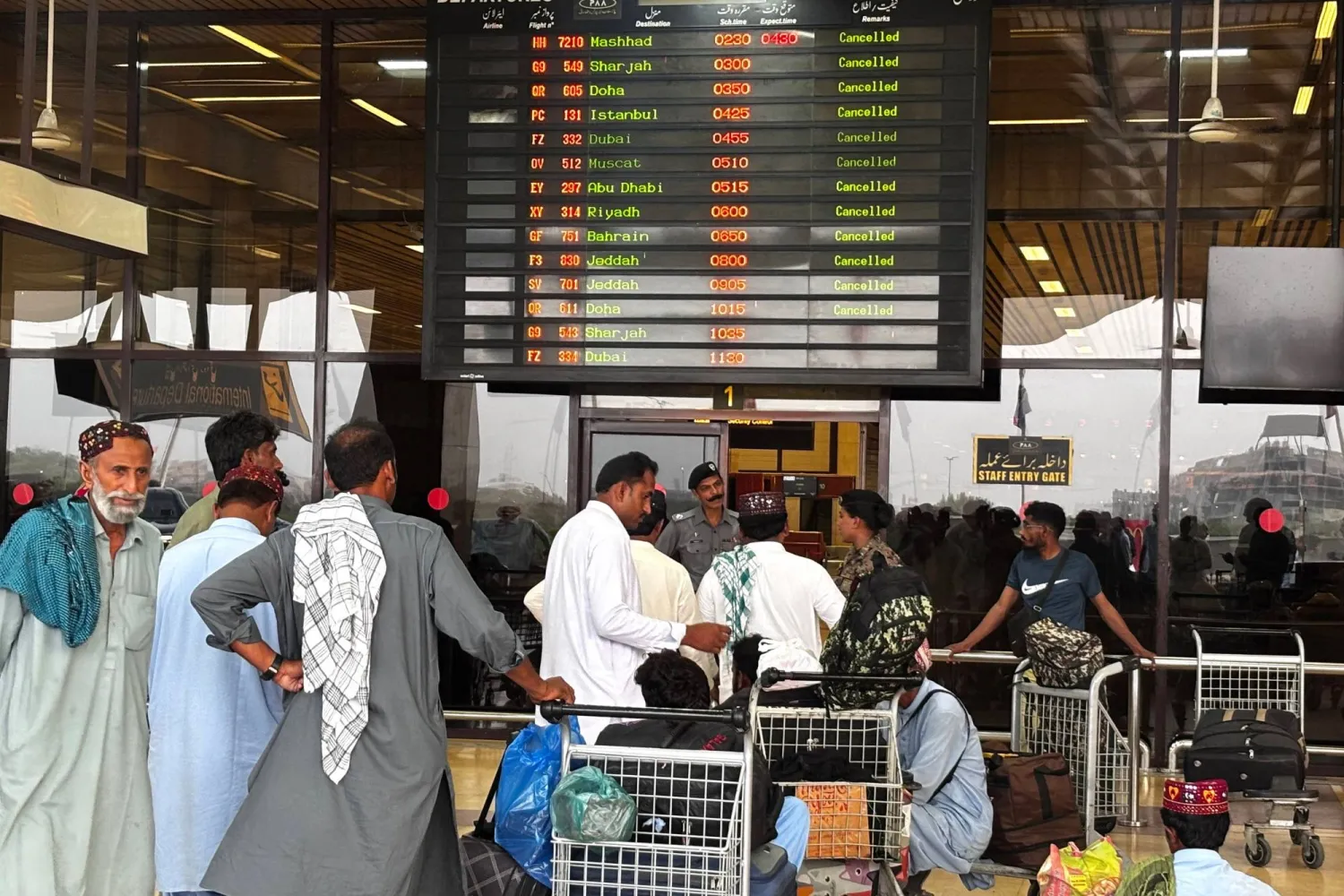 ركاب ينتظرون في مطار جناح الدولي بعد إلغاء جميع الرحلات الداخلية والدولية في كراتشي بباكستان (أ.ف.ب)