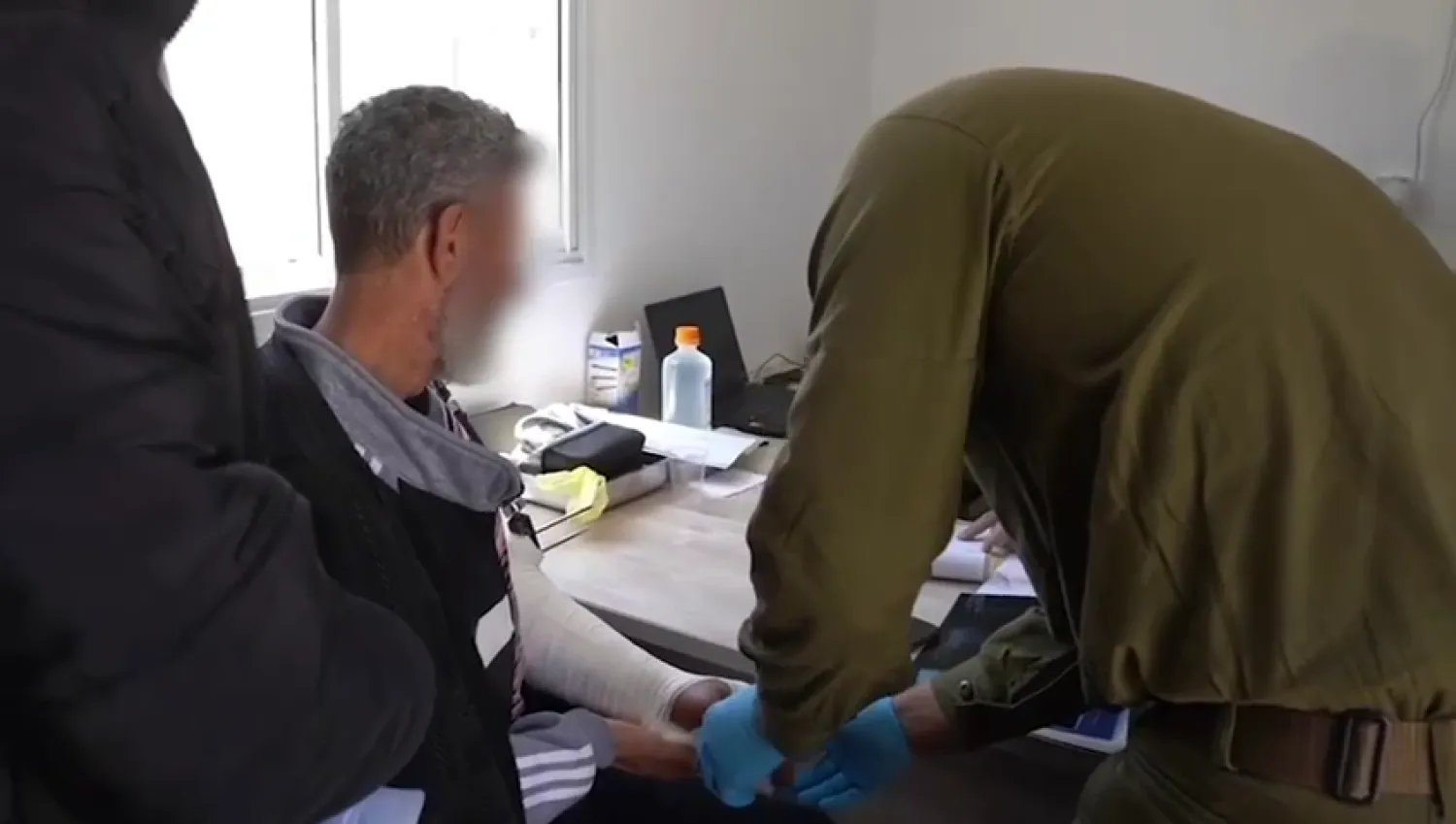 ممرّضون وأطباء عسكريون إسرائيليون مُوّهت وجوههم يعالجون رجلاً درزياً (لقطة من فيديو للجيش الإسرائيلي)