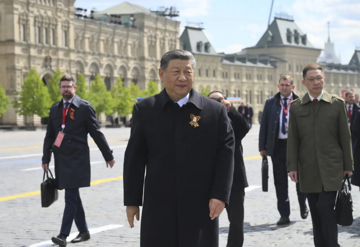الرئيس الصيني شي جينبينغ (وسط) يتجول في الساحة الحمراء بعد العرض العسكري بمناسبة يوم النصر في موسكو (أ.ب)