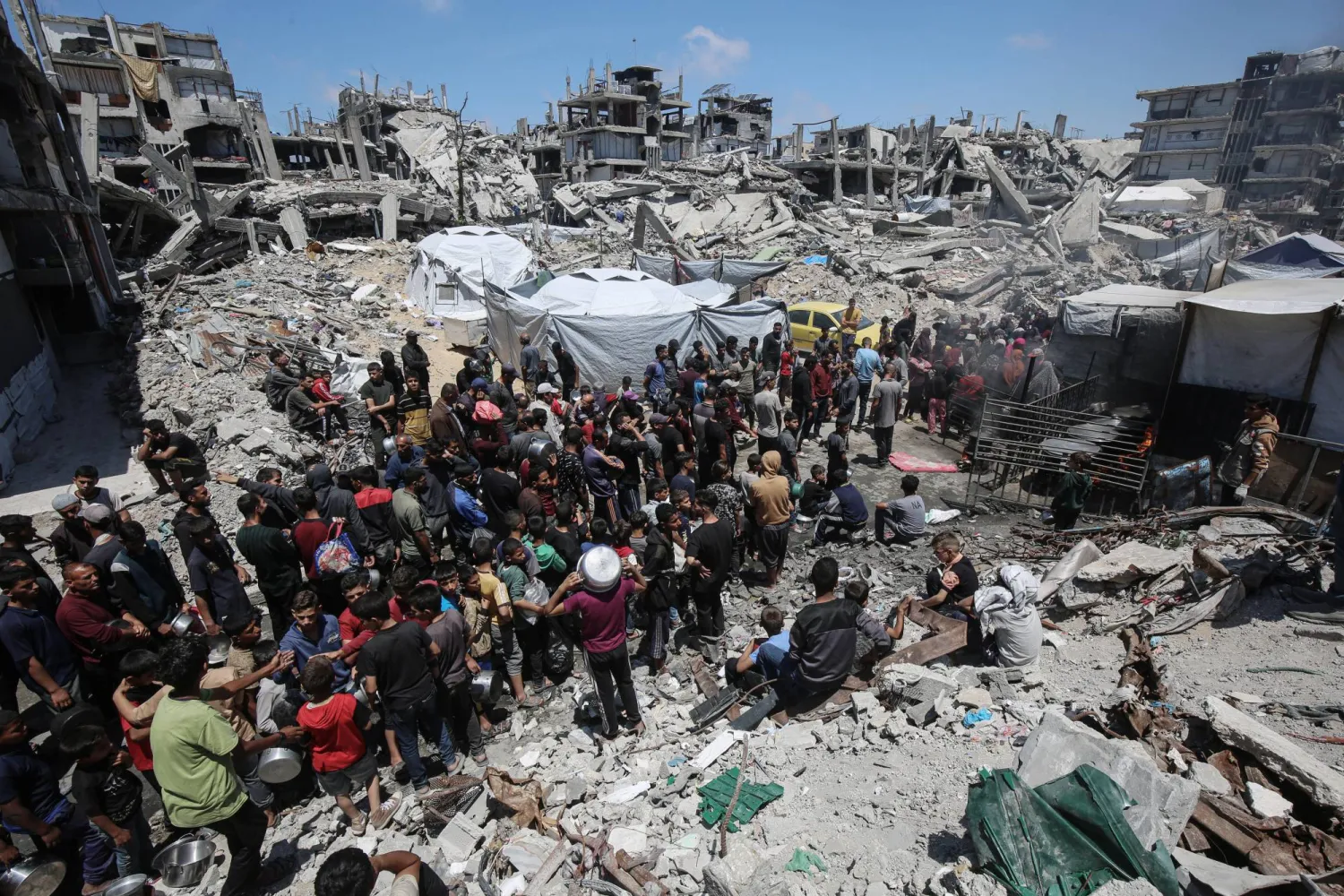 فلسطينيون في بيت لاهيا يصطفون في طوابير طويلة لتلقي حصتهم من الطعام الذي توزعه منظمات خيرية في غزة (د.ب.أ)