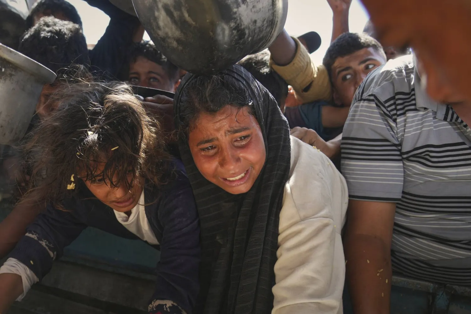 طفلة تبكي للحصول على الطعام المتبرَّع به في مطبخ مجتمعي بخان يونس (أ.ب)