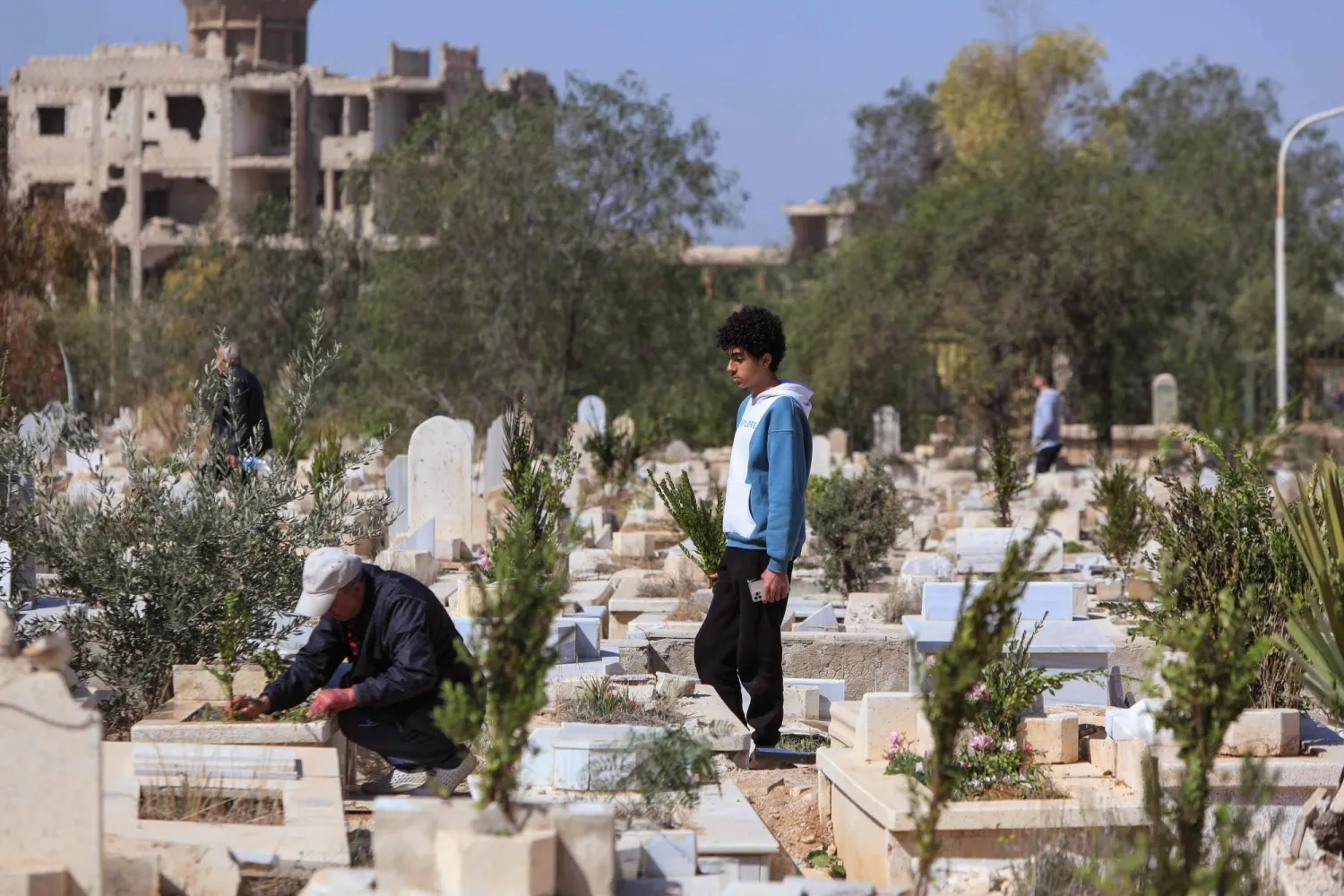 زيارة قبور الأقارب في المقبرة المتضرّرة بمخيم اليرموك للاجئين الفلسطينيين بدمشق (أرشيفية - أ.ف.ب)