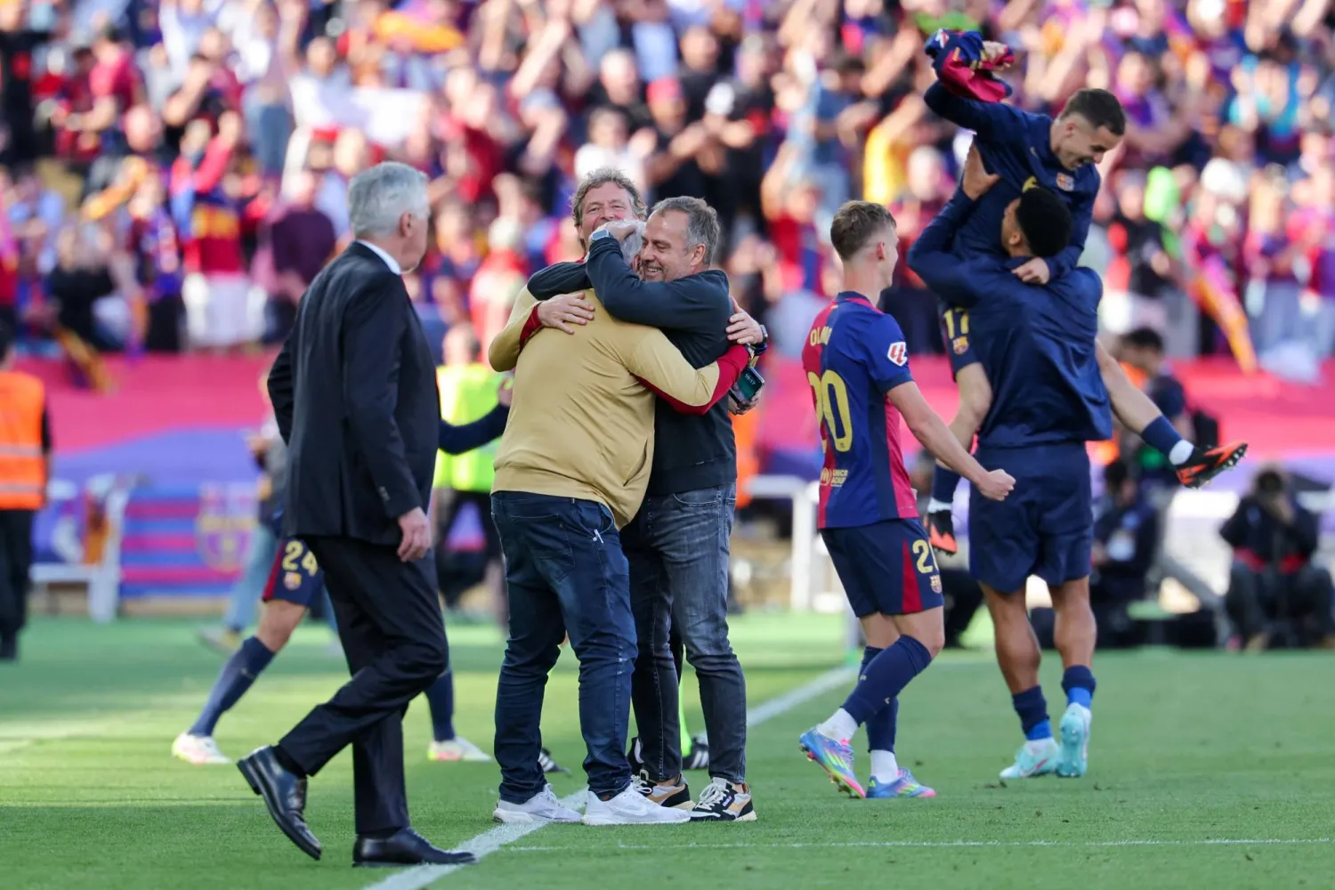 لاعبو برشلونة يحتفلون مع مدربهم فليك بالفوز المثير على ريال مدريد (أ.ف.ب)