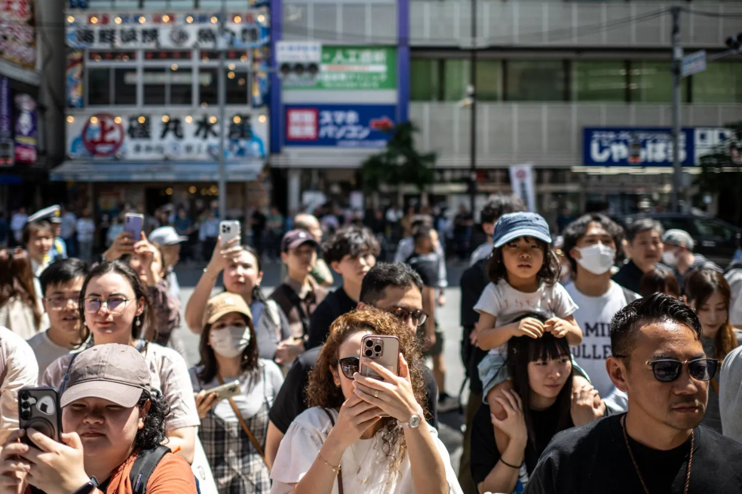 مشاهدون يلتقطون صوراً خلال أحد الاحتفالات الشعبية وسط العاصمة اليابانية طوكيو (أ.ف.ب)