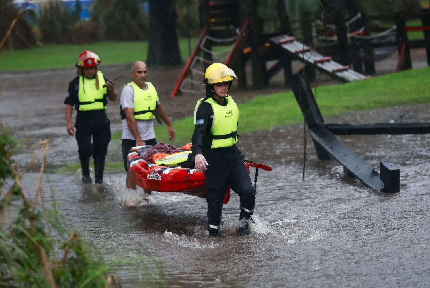 Firefighters carry a kayak amid flooding caused by heavy rains, in Capilla del Senor, in Buenos Aires, Argentina May 17, 2025. REUTERS/Matias Baglietto