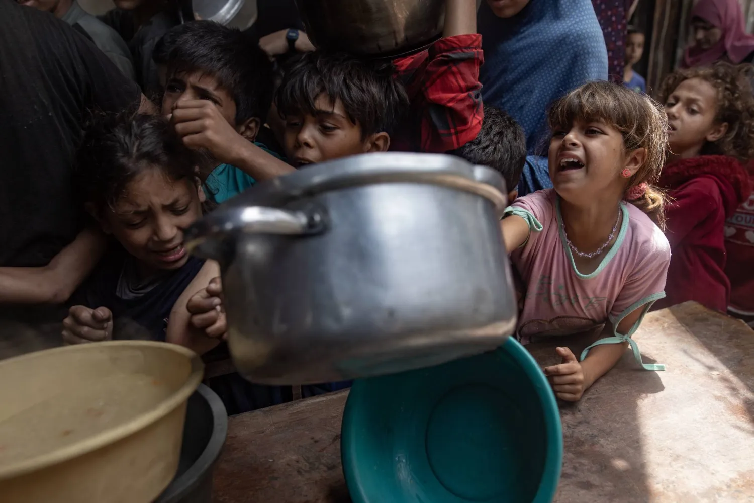 أطفال جوعى يتدافعون للحصول على طعام من «تكيَّة خيرية» في مدينة غزة (إ.ب.أ)