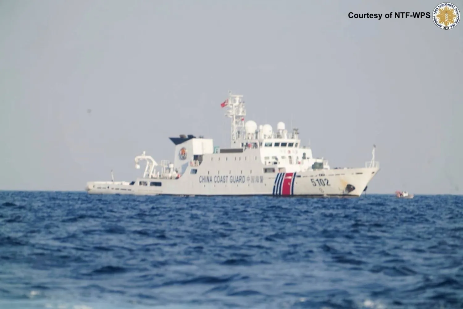 In this photo provided by the National Task Force West Philippine Sea (NTF-WPS), a Chinese Coast Guard ship patrols the area as Philippine inter-agency members visit Sandy Cay 2 at the South China Sea on Sunday April 27, 2025. (National Task Force West Philippine Sea via AP)