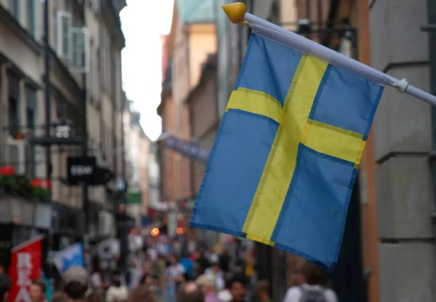 A Swedish flag hangs outside a store on a busy street as visitors walk past in the background in the old town of Stockholm, Sweden, July 14, 2023 REUTERS/Tom Little/File Photo