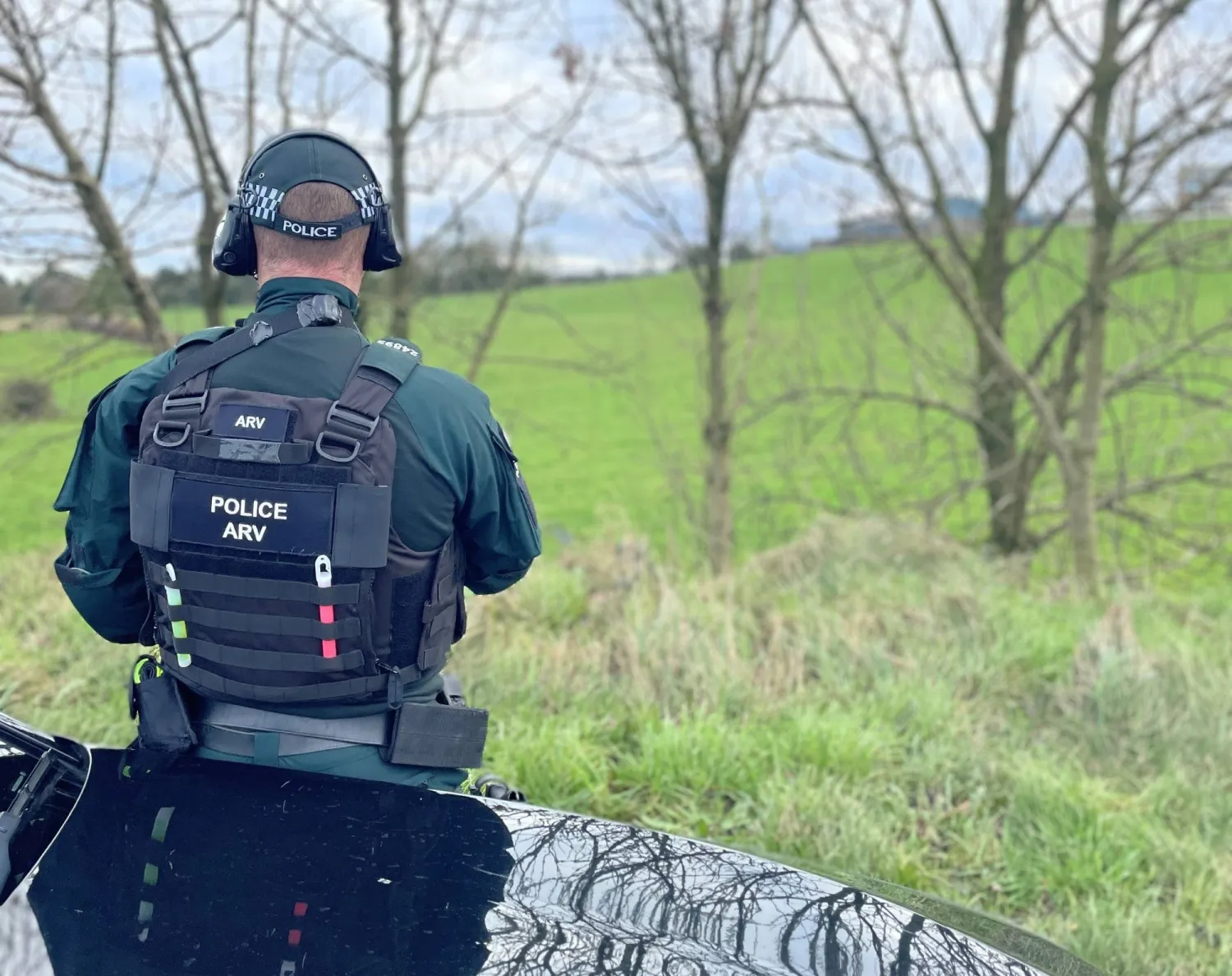 شرطي آيرلندي يقف بجوار سيارة للشرطة قرب أحد الطرق في بلفاست (الشرطة الآيرلندية)