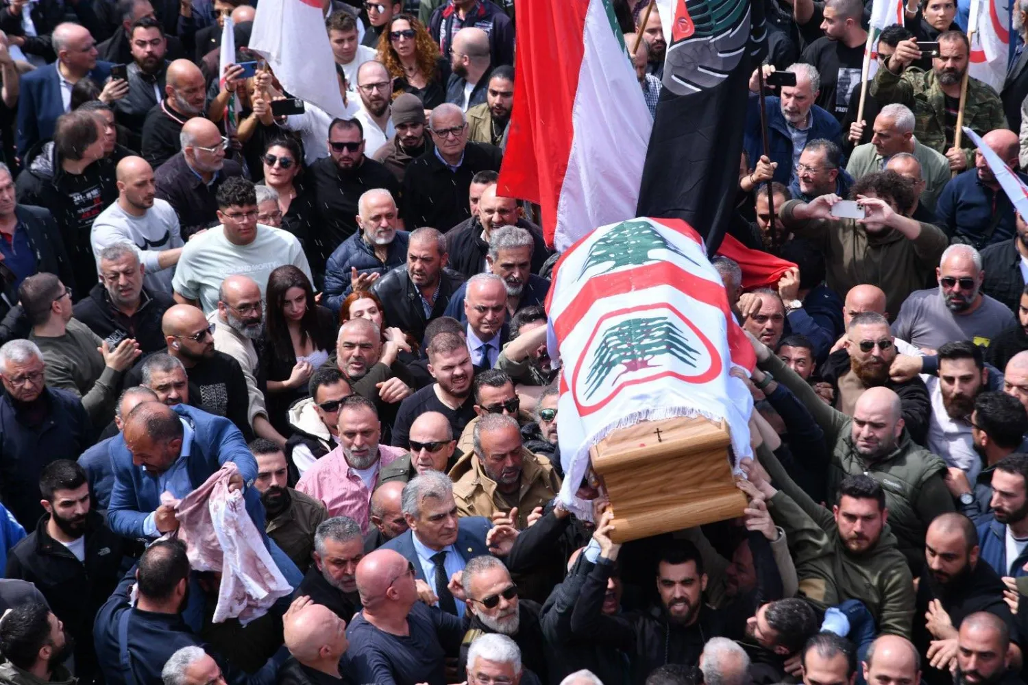 مناصرون لحزب «القوات اللبنانية» يرفعون نعش باسكال سليمان في جبيل خلال تشييعه في العام الماضي (أرشيفية - إعلام القوات)