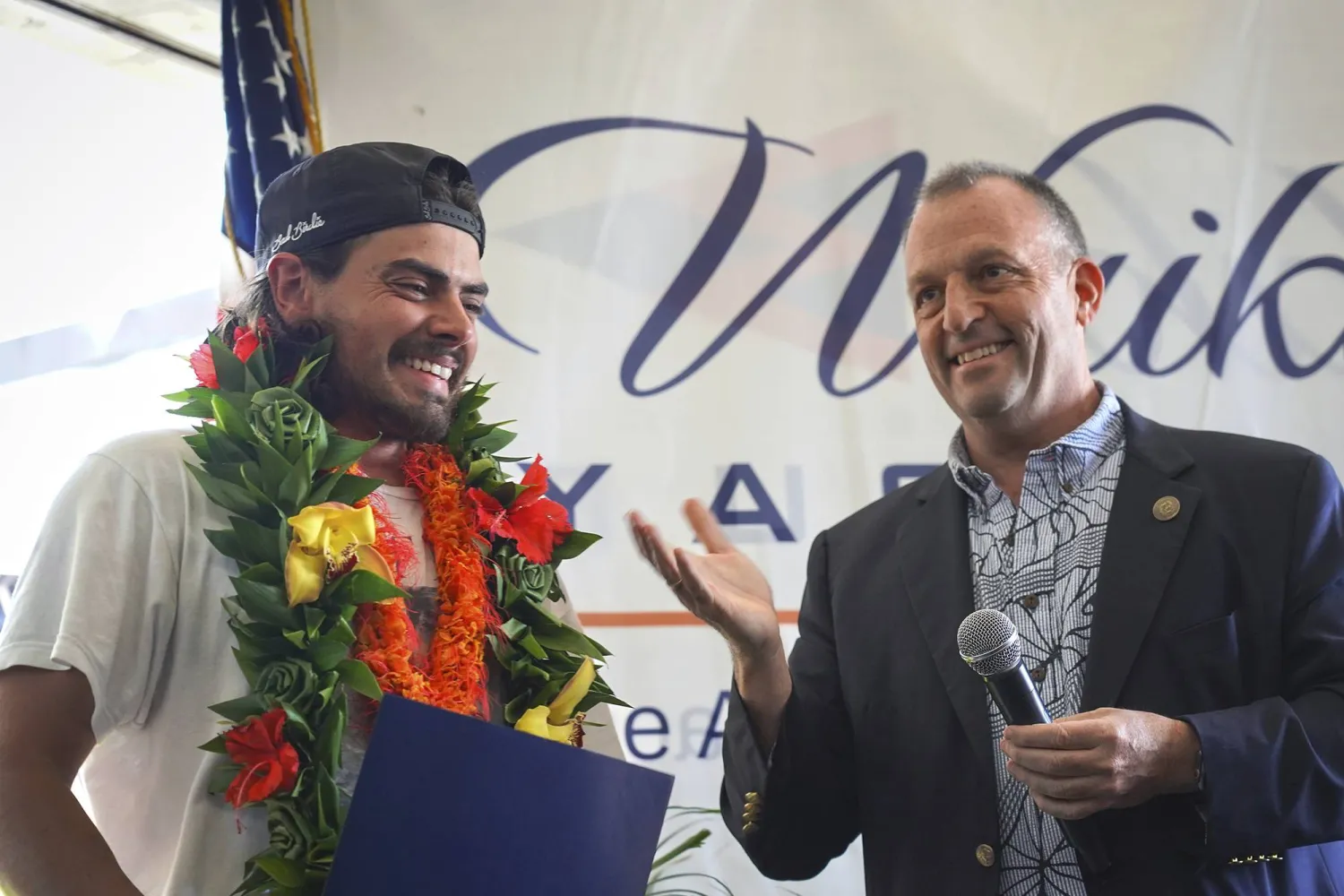 Governor Josh Green presents a proclamation to Oliver Widger, 29-year-old Oregon man who sailed from Oregon to Hawai'i, on Saturday, May 24, 2025 in Waikiki, Hawaii. (AP Photo/Michelle Bir)