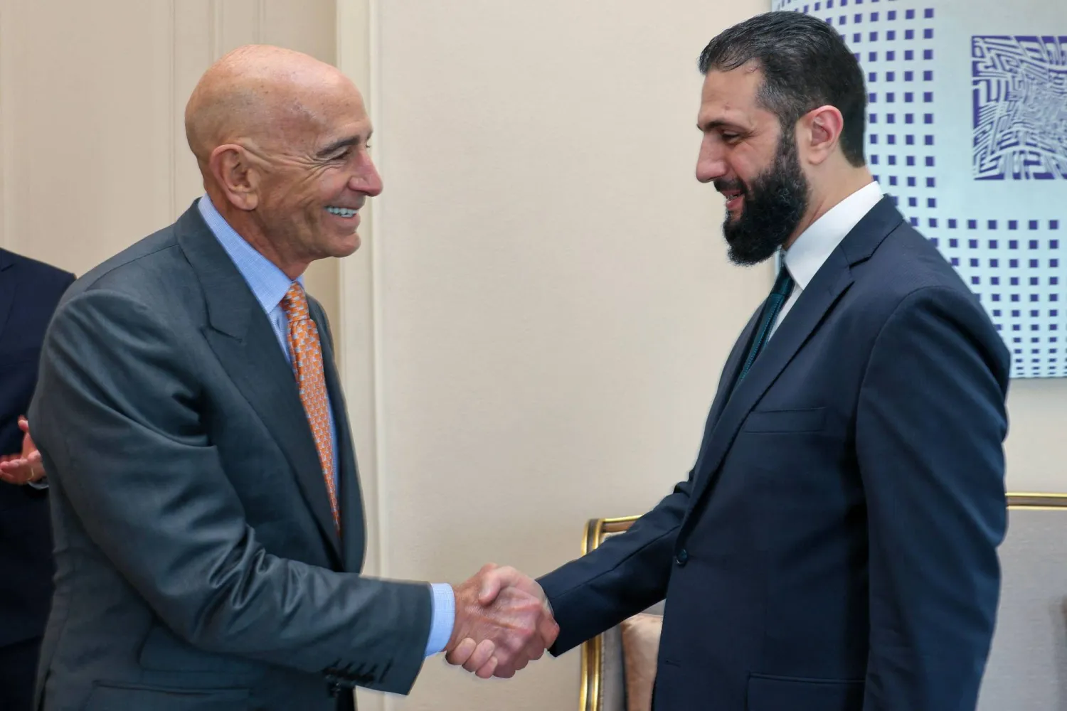 This handout photograph taken and released by Turkish Foreign Ministry press service on May 24, 2025, shows US Ambassador to Türkiye Thomas Barrack (L) shakes hands with Syria's interim President Ahmed al-Sharaa (R) during a meeting in Istanbul. (Photo by Handout / TURKISH FOREIGN MINISTRY / AFP)
