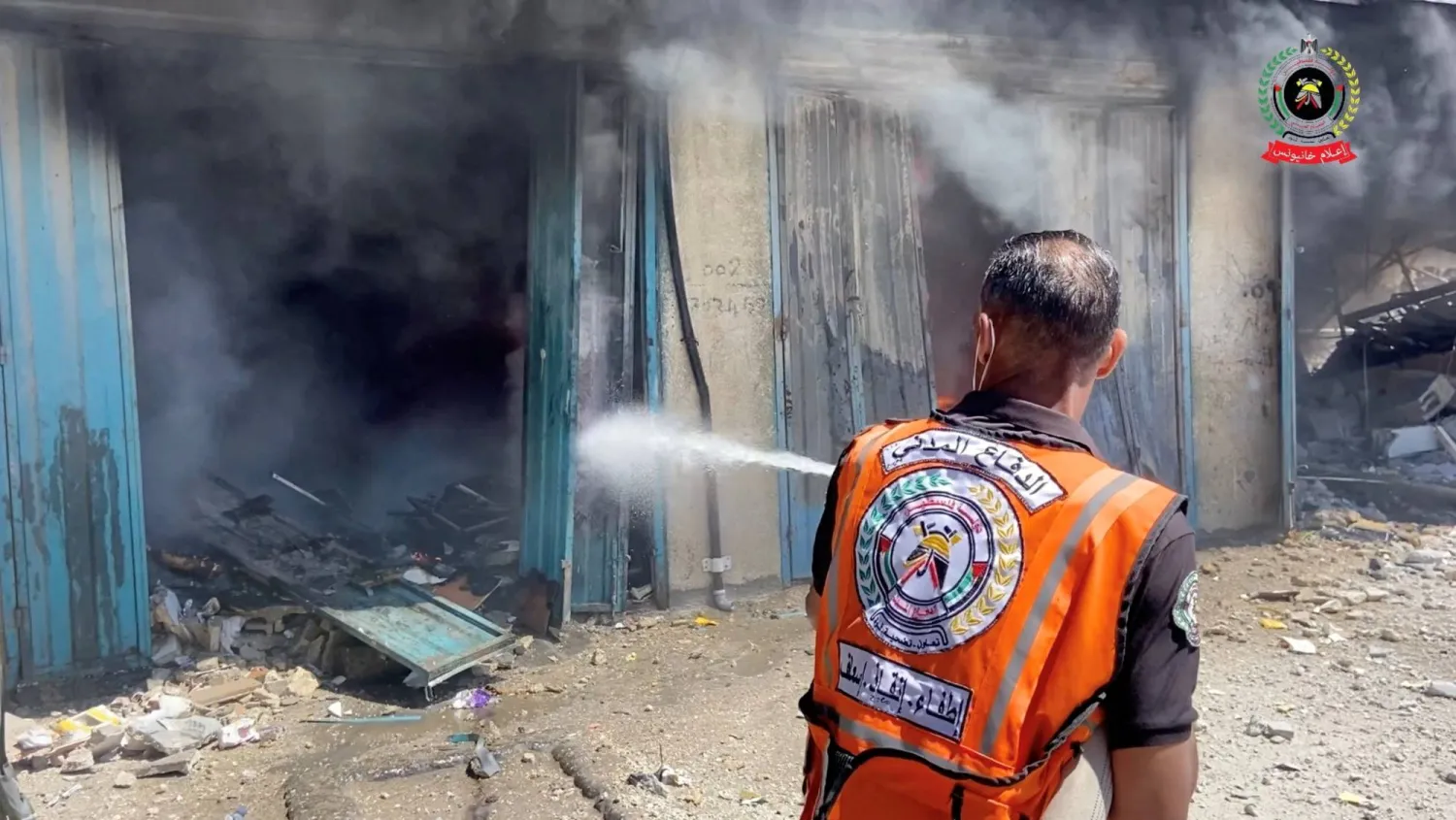 عنصر من الدفاع المدني في قطاع غزة خلال إخماد حريق في خان يونس بعد قصف إسرائيلي (رويترز)