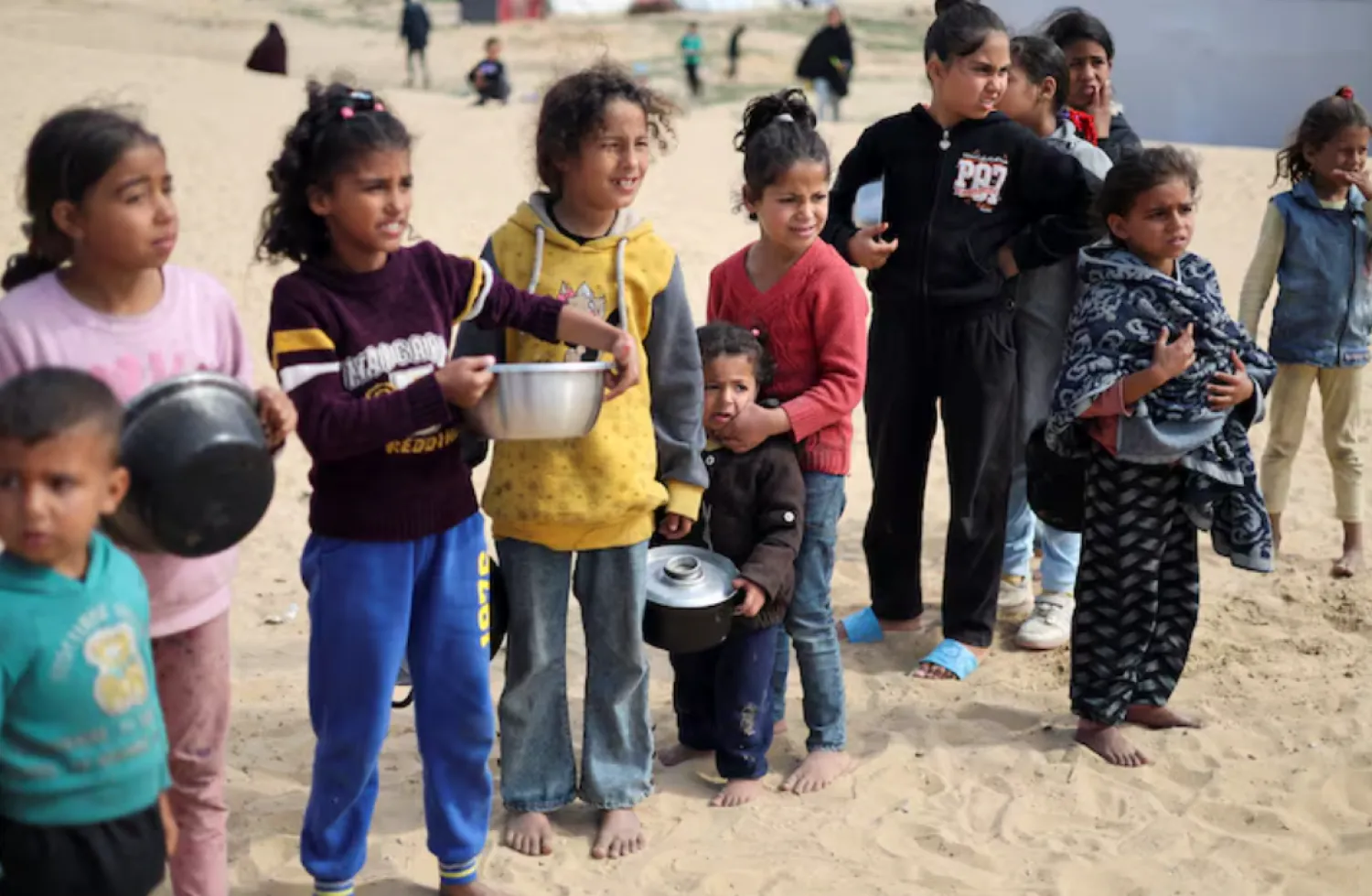Displaced Palestinian children wait to receive free food at a tent camp, amid food shortages, as the conflict between Israel and Hamas continues, in Rafah in the southern Gaza Strip, February 27, 2024. REUTERS/Ibraheem Abu Mustafa 
