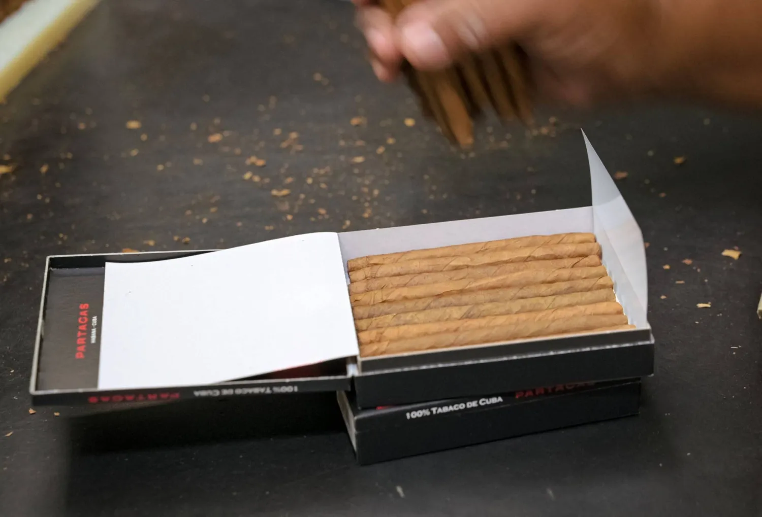 عاملة تُعبّئ السيغاريو يدوياً في مصنع للسيغار بهافانا (أ.ف.ب)