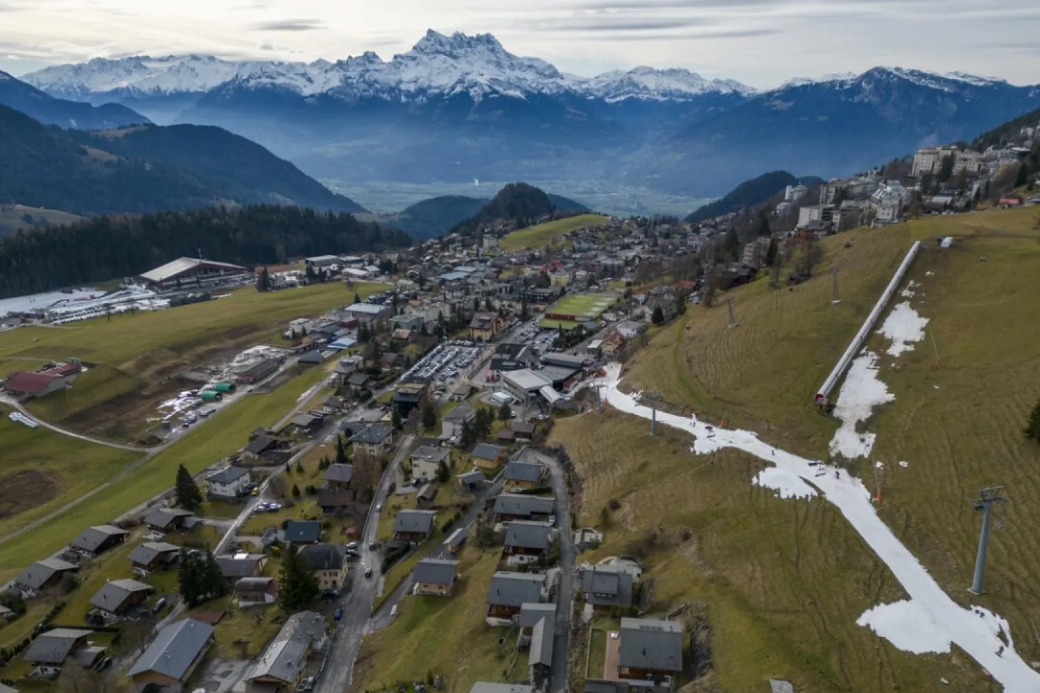 File: Skiers pass on a small layer of artificial snow amid warmer-than-usual winter temperatures in the Alps in Leysin, Switzerland, January 4, 2023. REUTERS/Denis Balibouse 