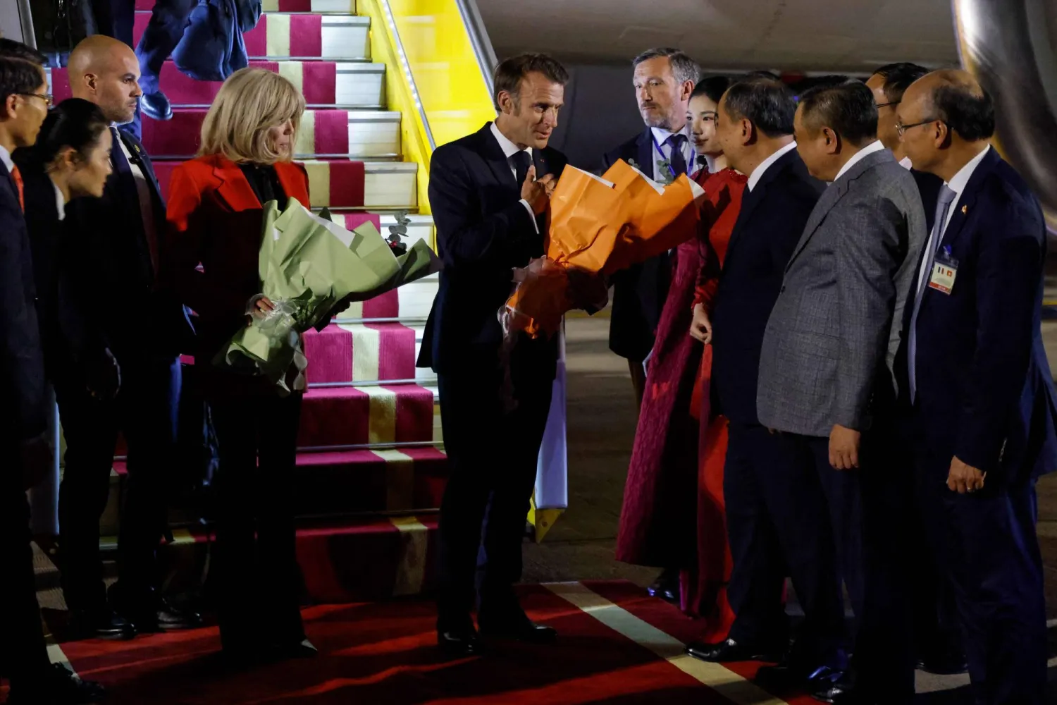 ماكرون وعقيلته بريجيت لدى استقبالهما في مطار نوي باي الدولي في هانوي الأحد 25 مايو (أ.ف.ب)