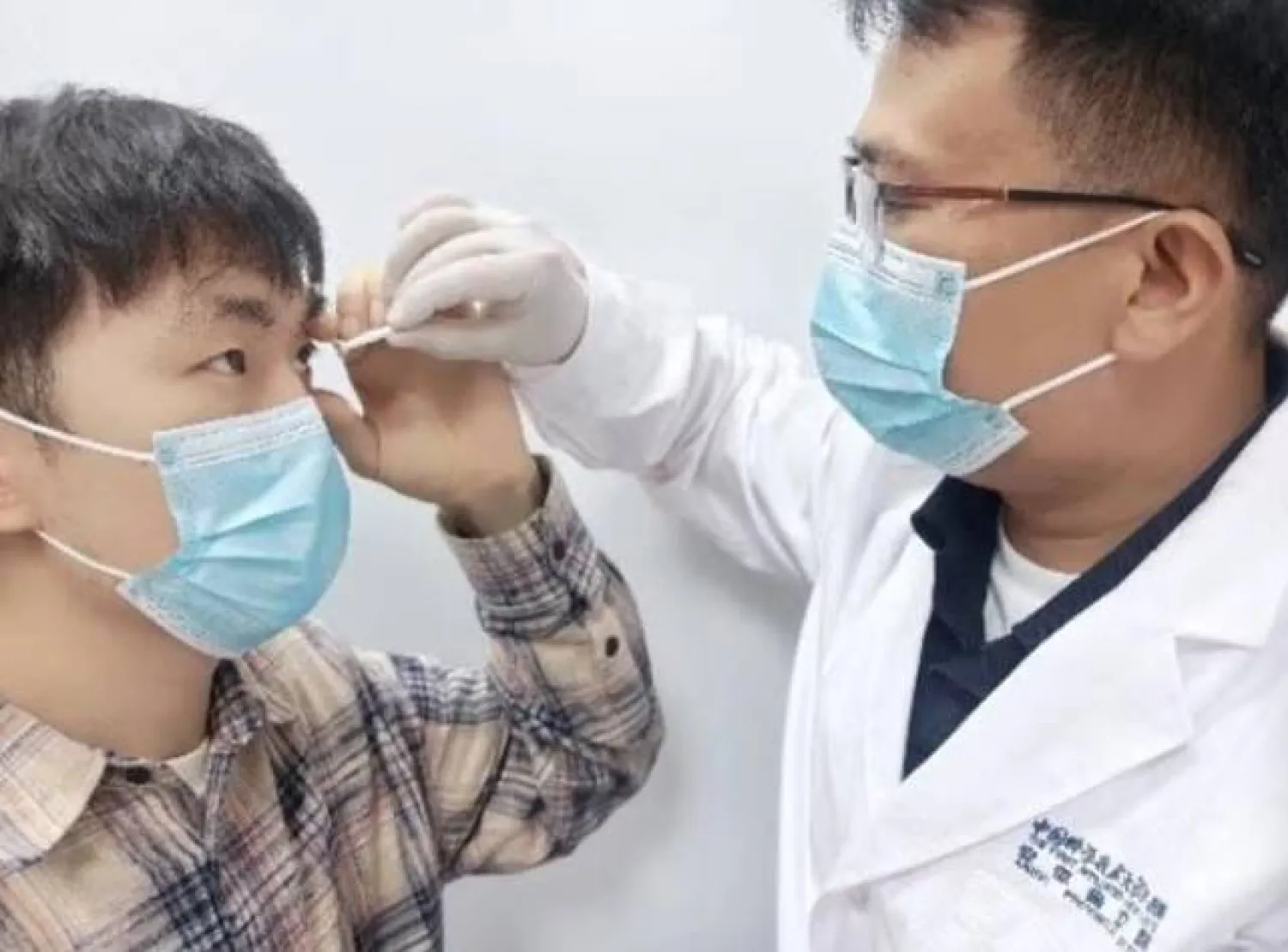 باحث يضع العدسات في عين أحد المشاركين (جامعة العلوم والتكنولوجيا في الصين)