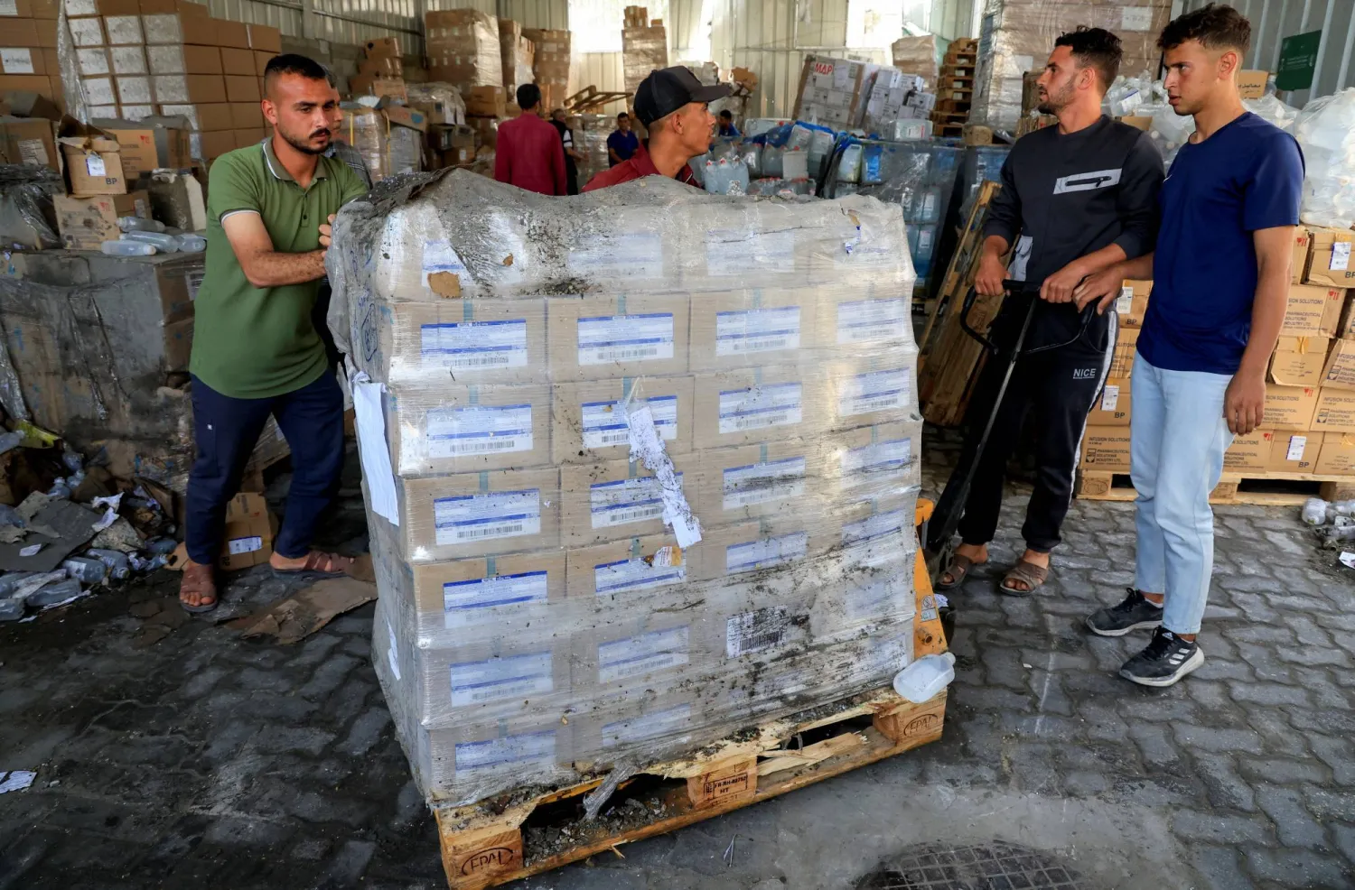 موظفون فلسطينيون يتفقدون مستودع الأدوية في مستشفى ناصر جنوب قطاع غزة بعد غارة إسرائيلية 19 مايو 2025 (رويترز)
