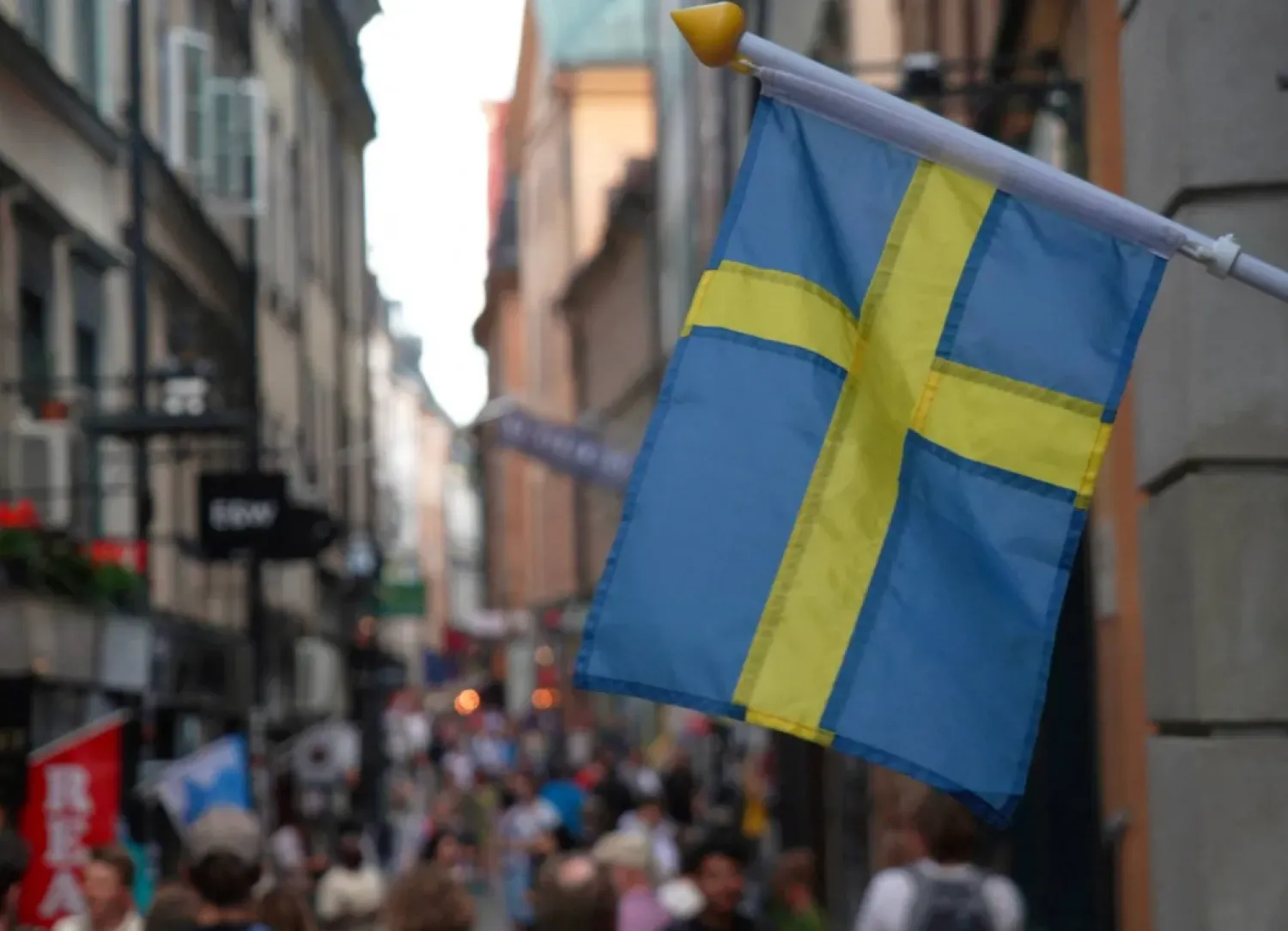 A Swedish flag hangs outside a store on a busy street as visitors walk past in the background in the old town of Stockholm, Sweden, July 14, 2023 REUTERS/Tom Little/File Photo 