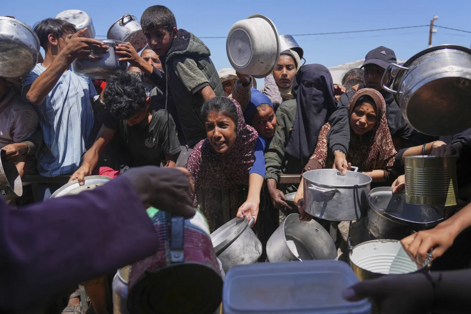 تدافُع للحصول على غذاء من تكية خيرية في منطقة المواصي بخان يونس يوم الجمعة (أ.ب)
