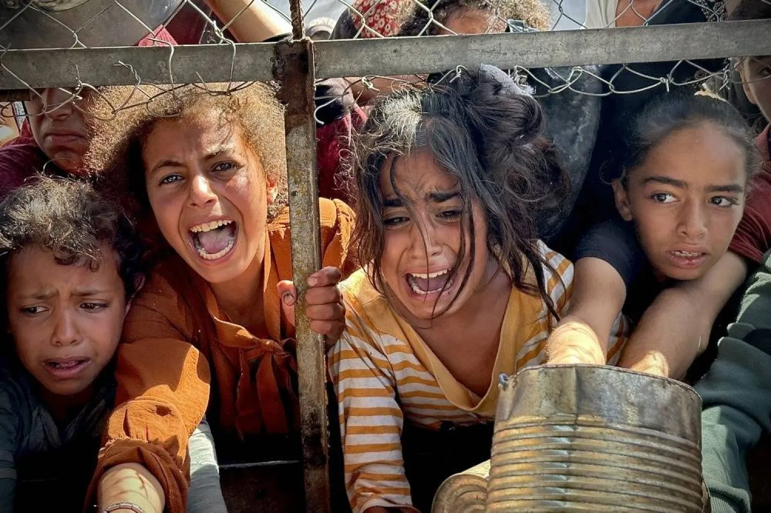 جانب من الأطفال الجياع المتهافتين على توزيع المساعدات الغذائية في غزة (أ.ف.ب)